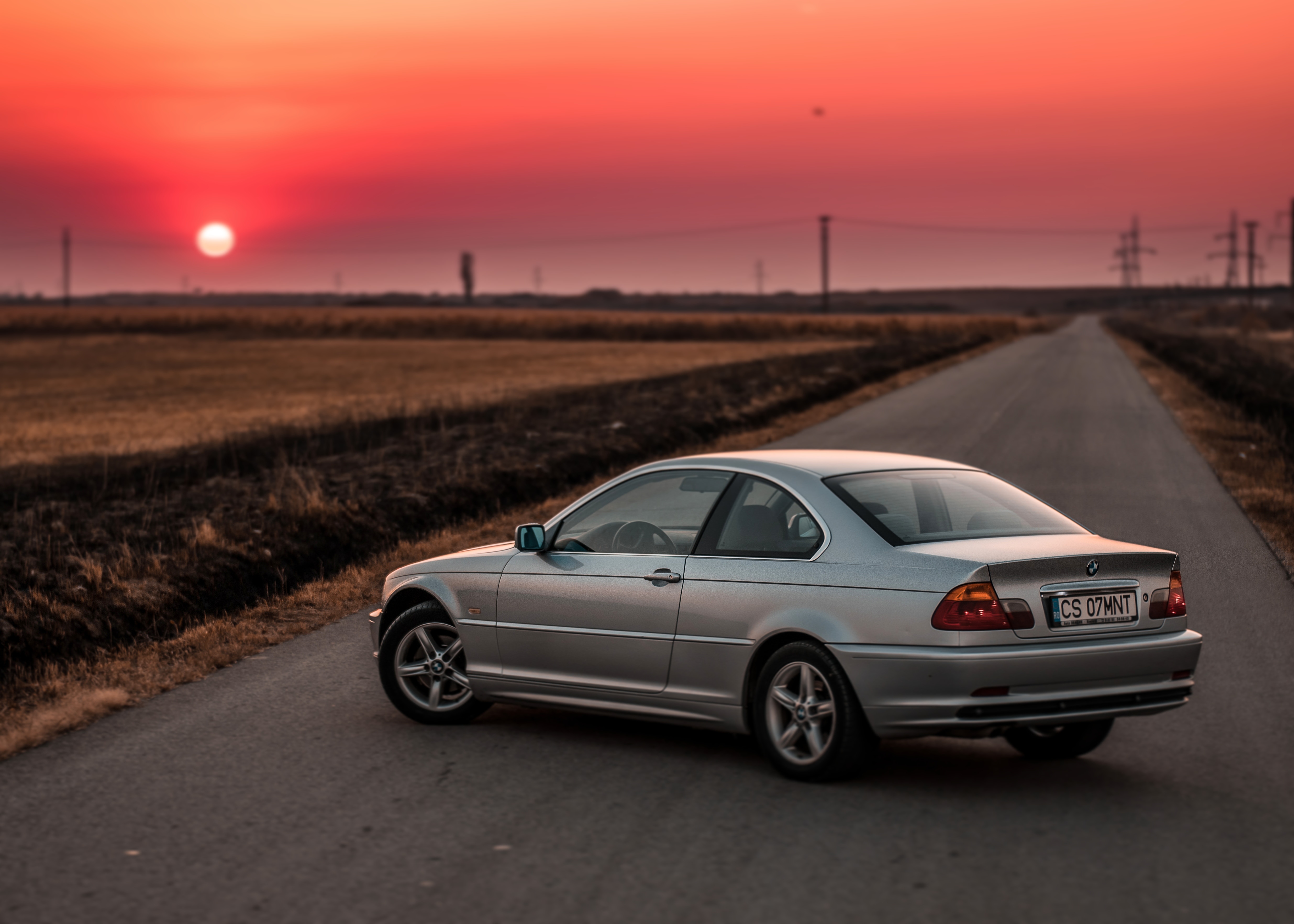 Silver BMW coupe on a road at sunset HD Wallpaper