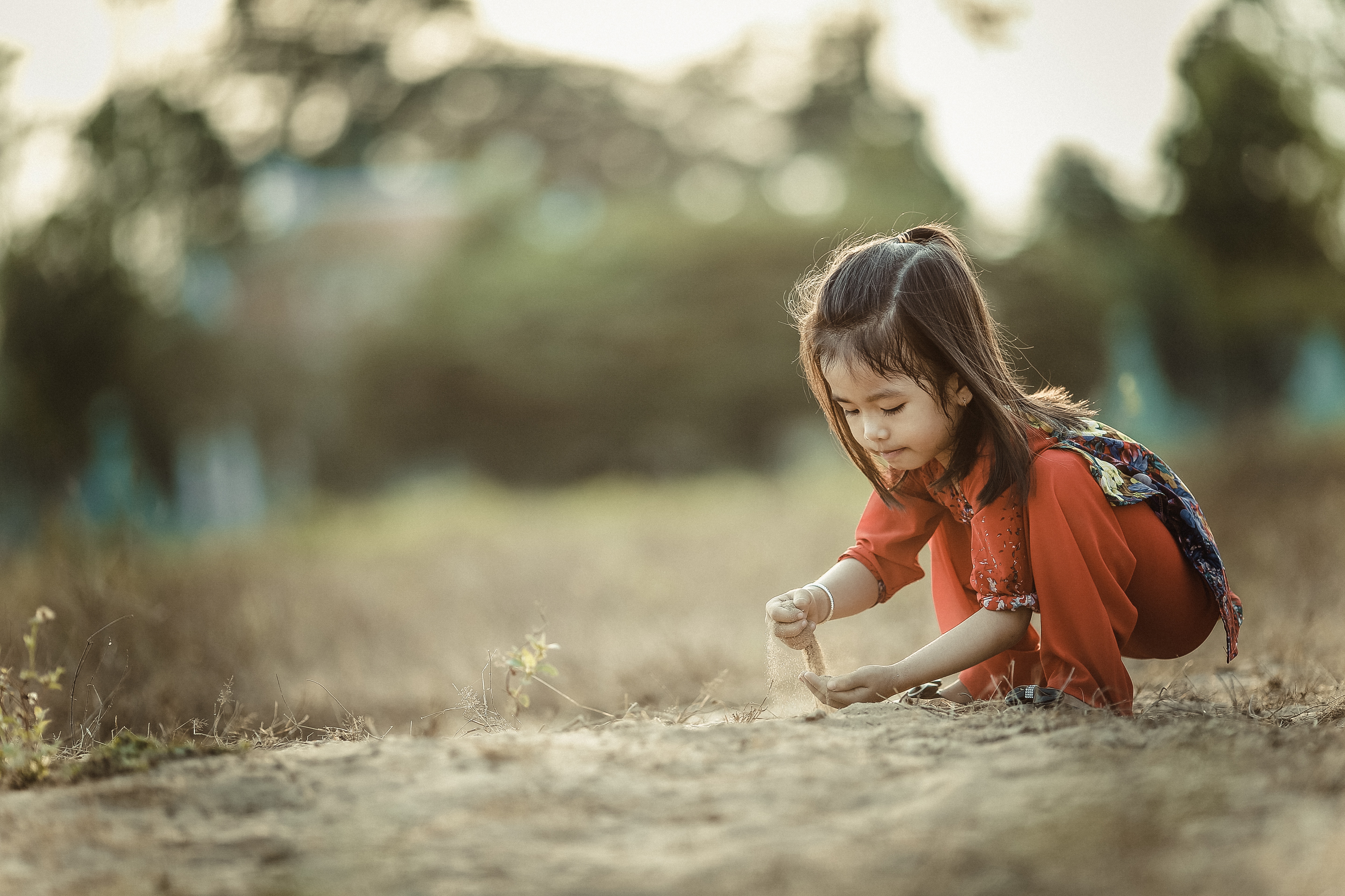 Girl playing with sand in a field HD Wallpaper