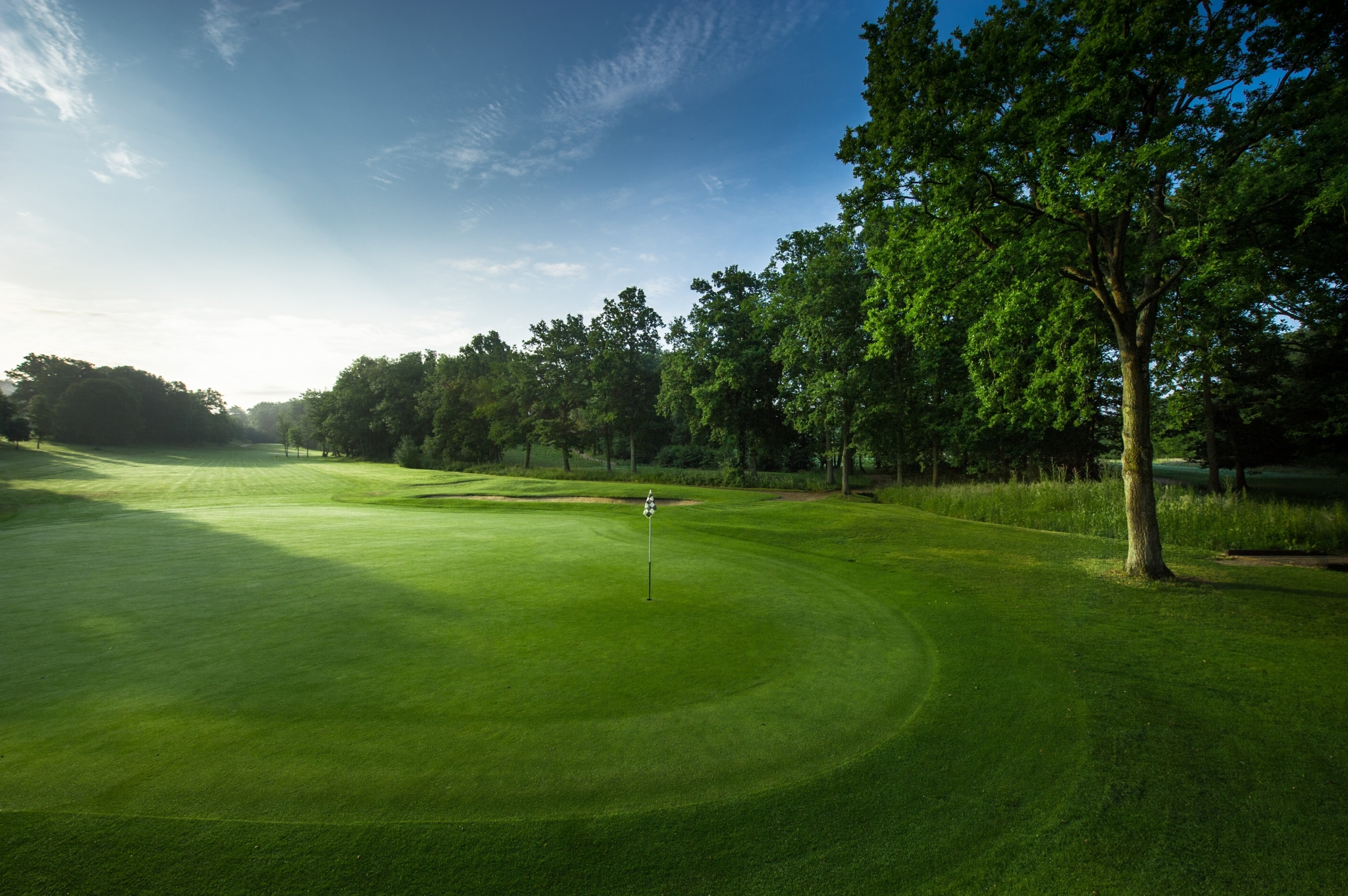 Golf course with flag on green HD Wallpaper