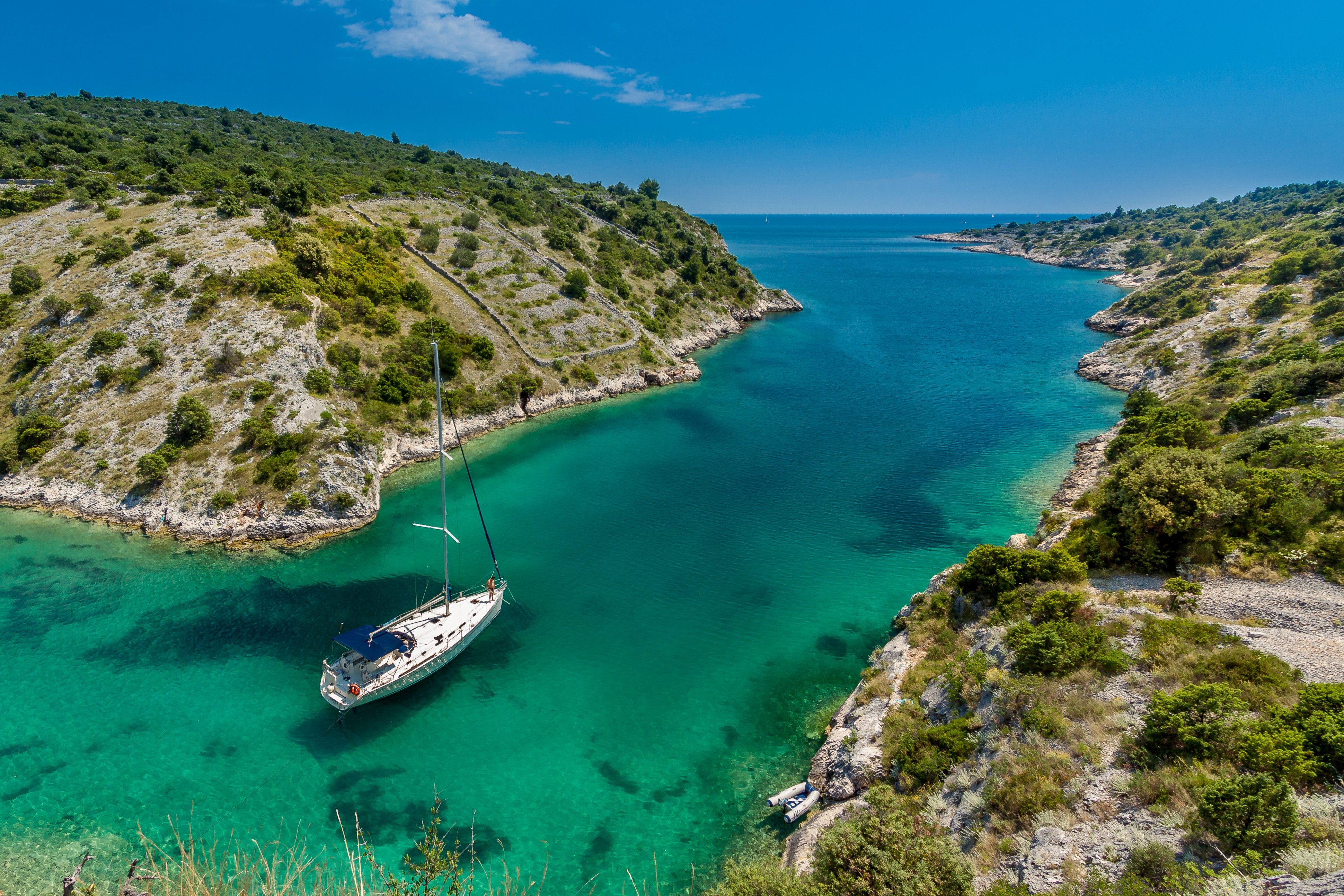 Sailboat anchored in a Mediterranean cove HD Wallpaper