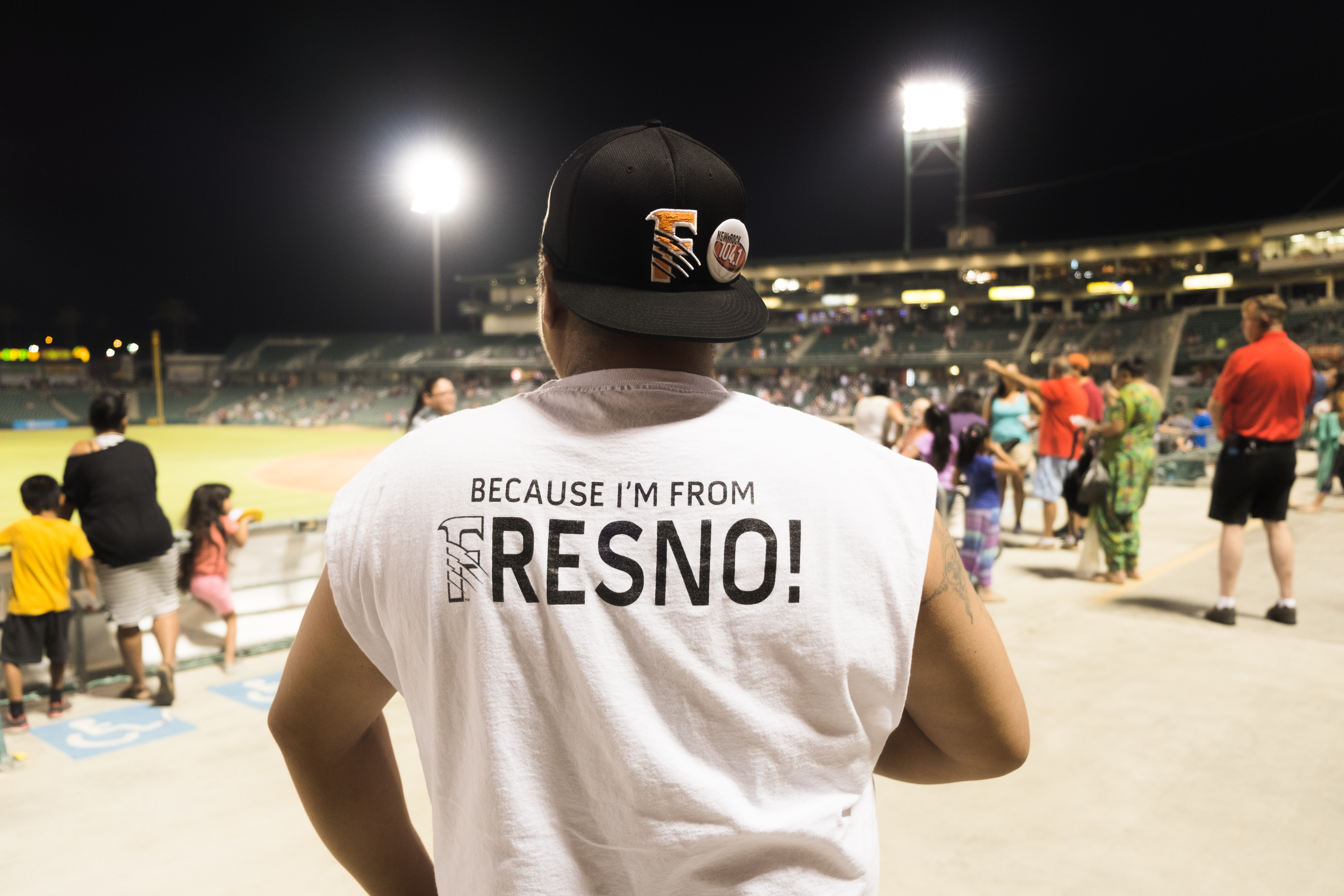Man wearing a "Because I'm from Fresno!" shirt at a stadium HD Wallpaper