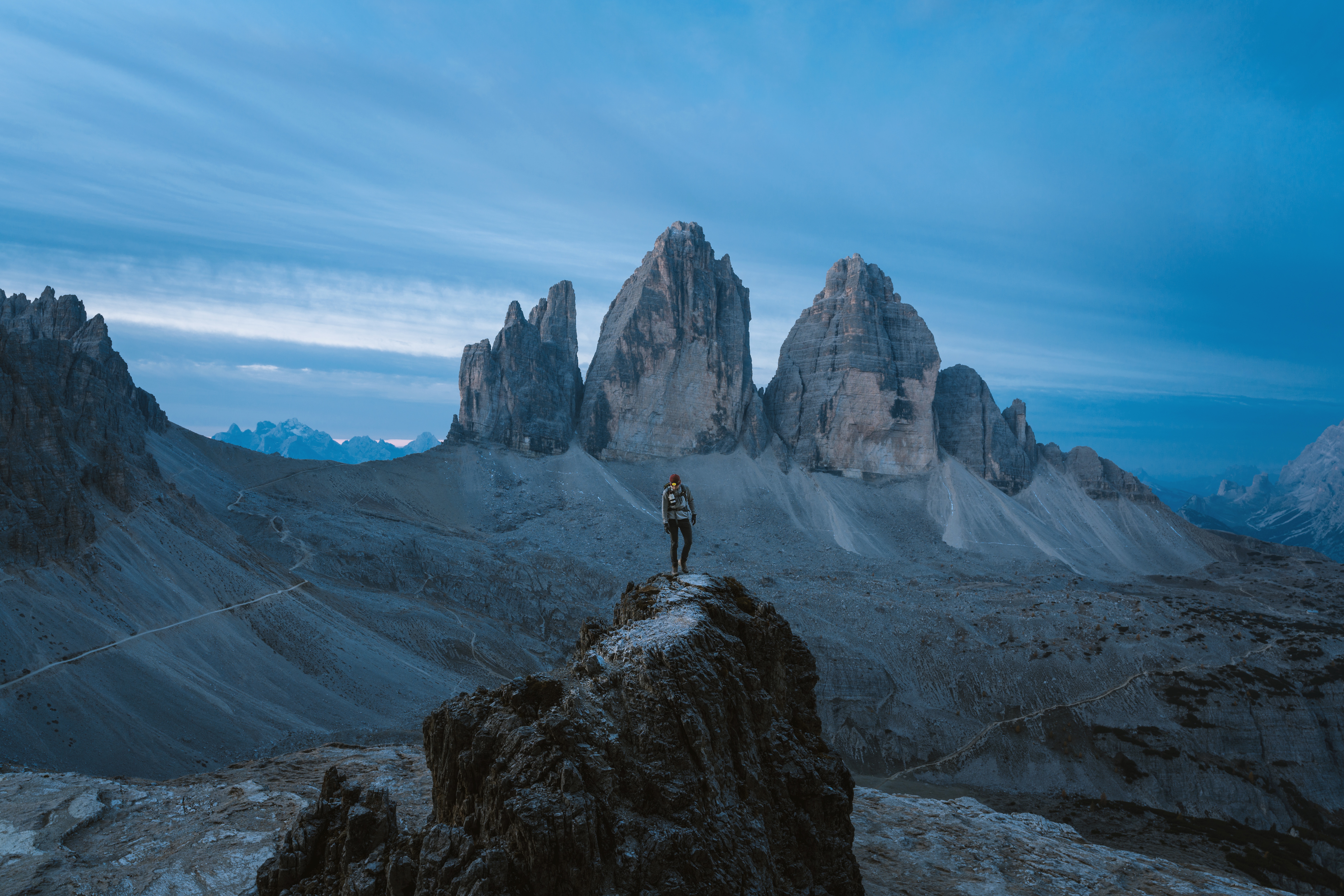 Person standing on a rock with Tre Cime di Lavaredo mountains HD Wallpaper