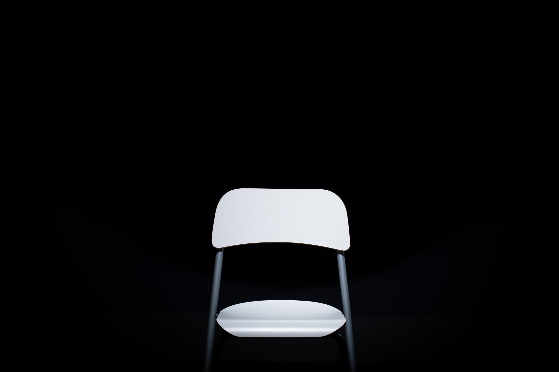 Minimalist white chair against a black background HD Wallpaper