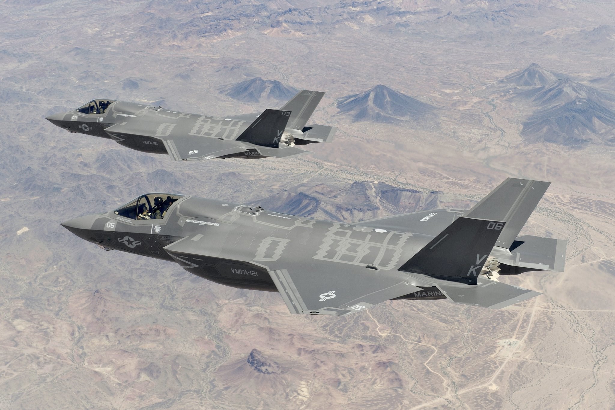 Lockheed Martin F-35 Lightning II jets flying over desert mountains HD Wallpaper