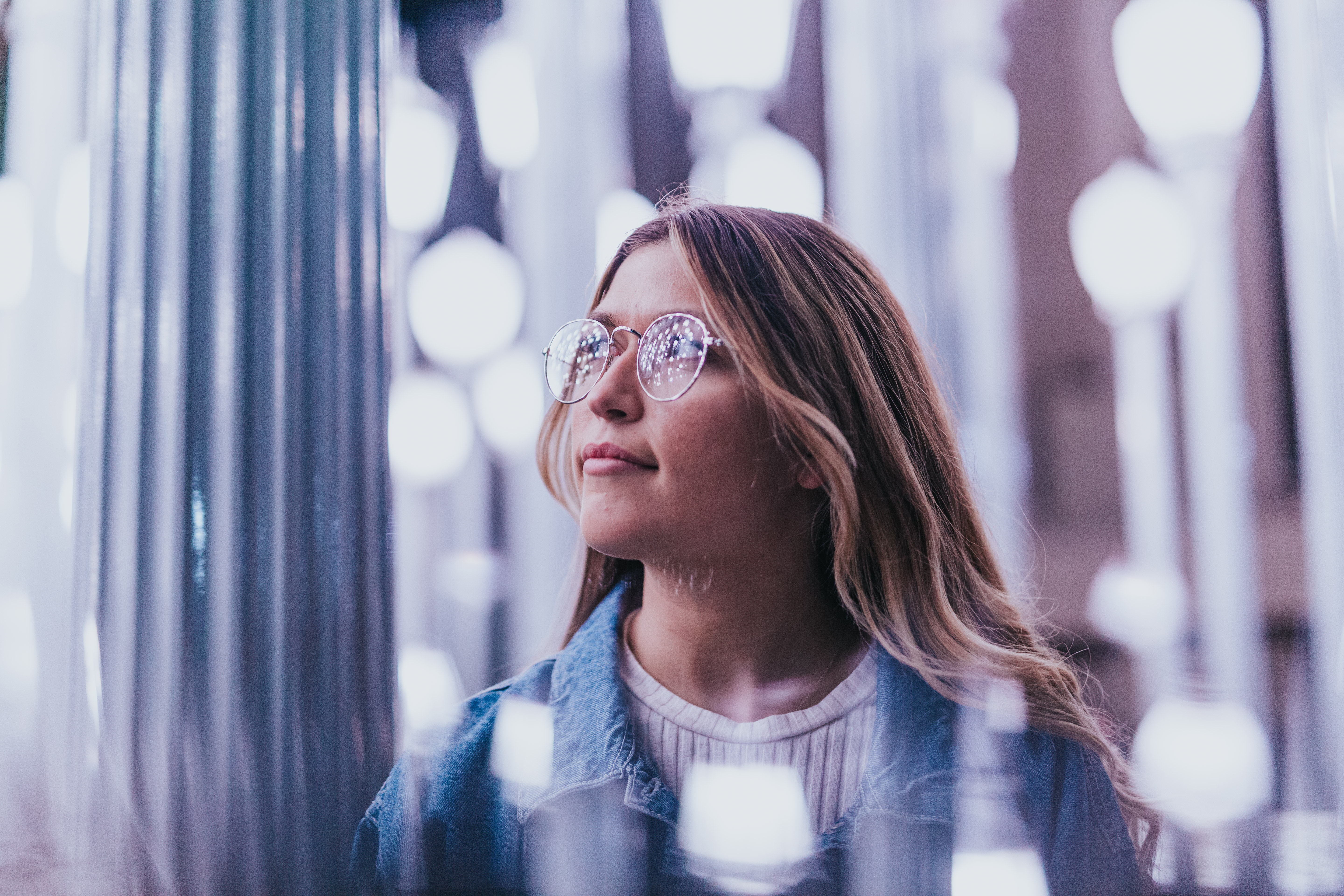 Woman with glasses in urban lights HD Wallpaper