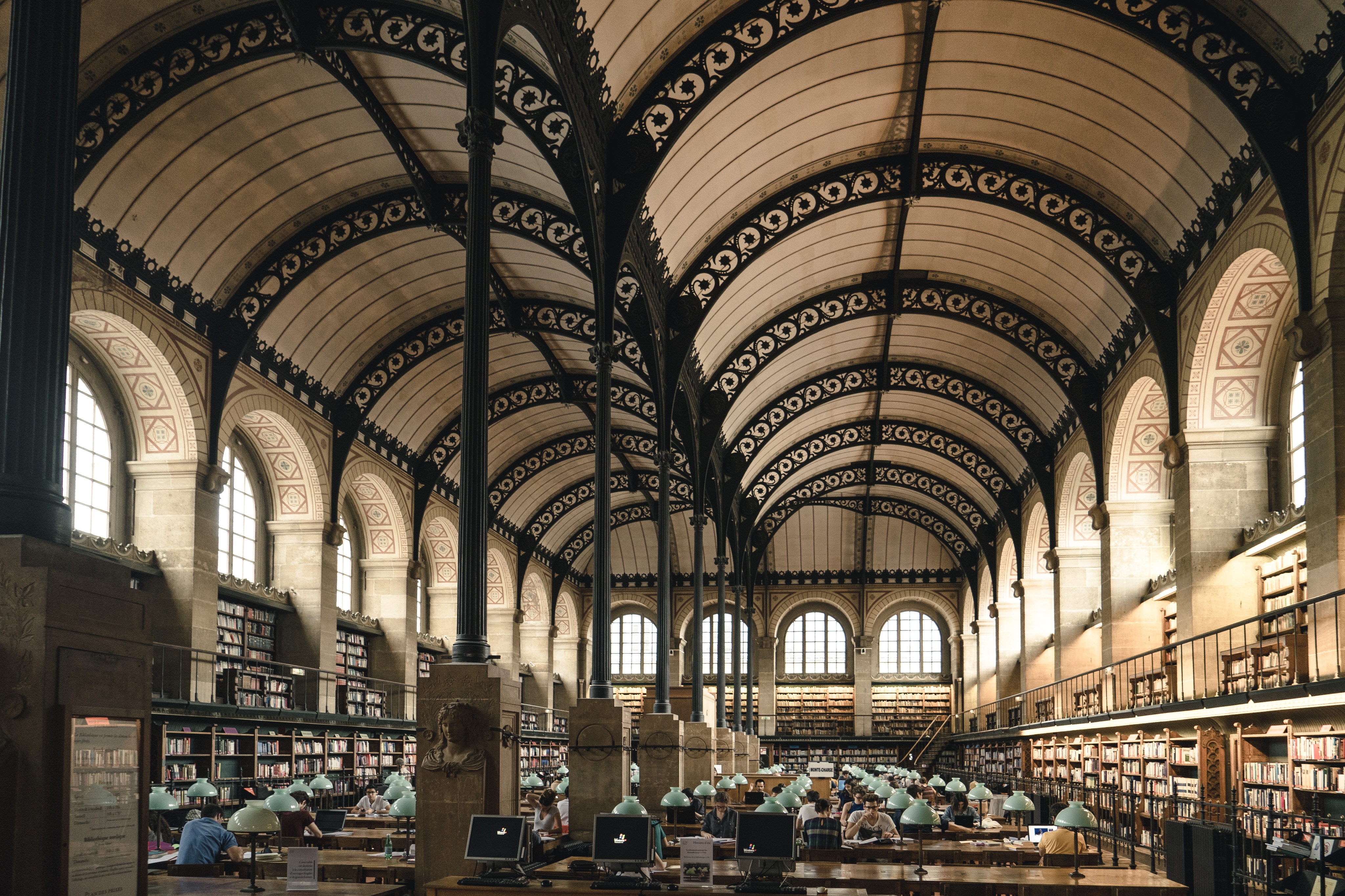 Interior of a historic library with vaulted ceilings and bookshelves HD Wallpaper