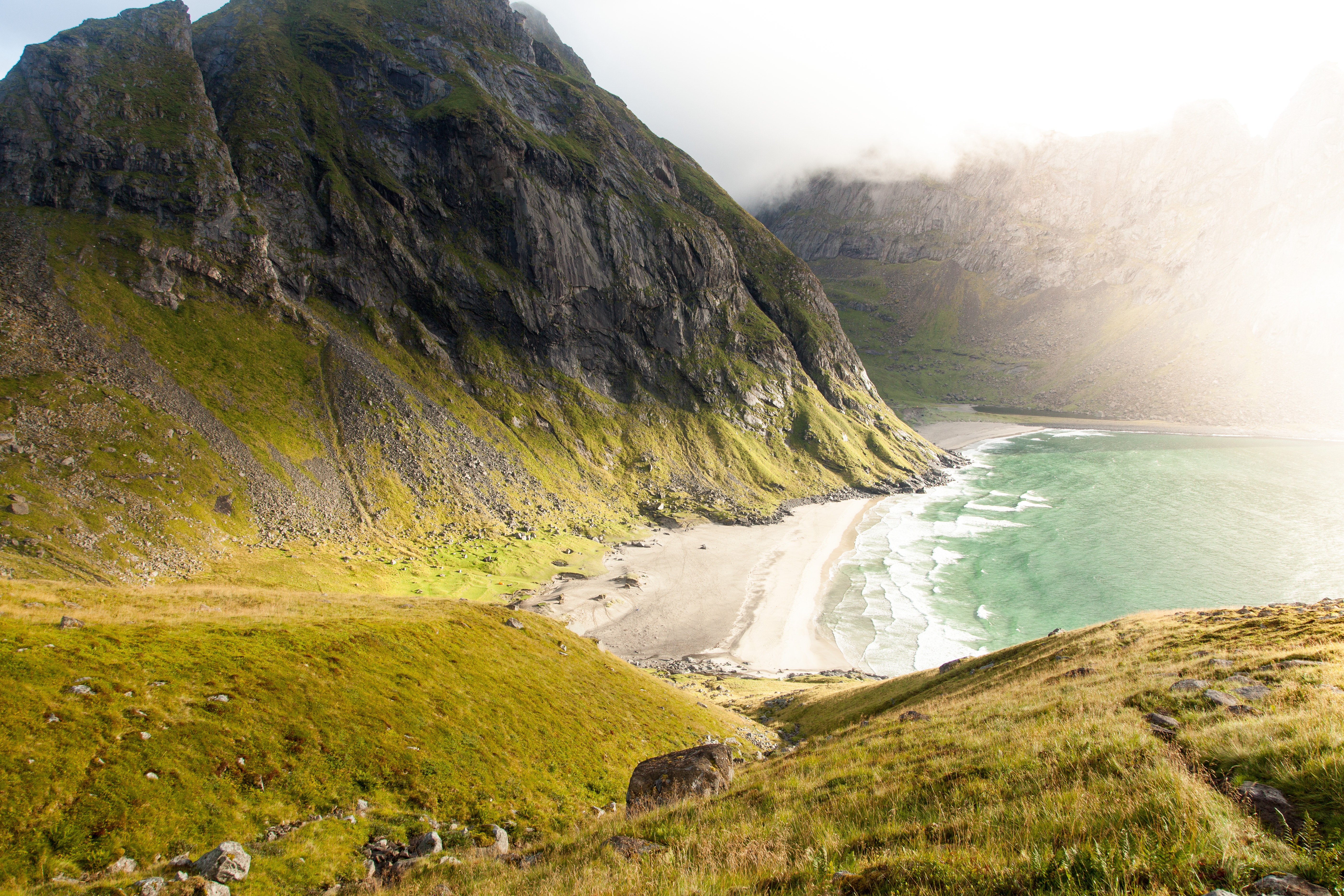 Green mountains meet a sandy beach and turquoise ocean HD Wallpaper