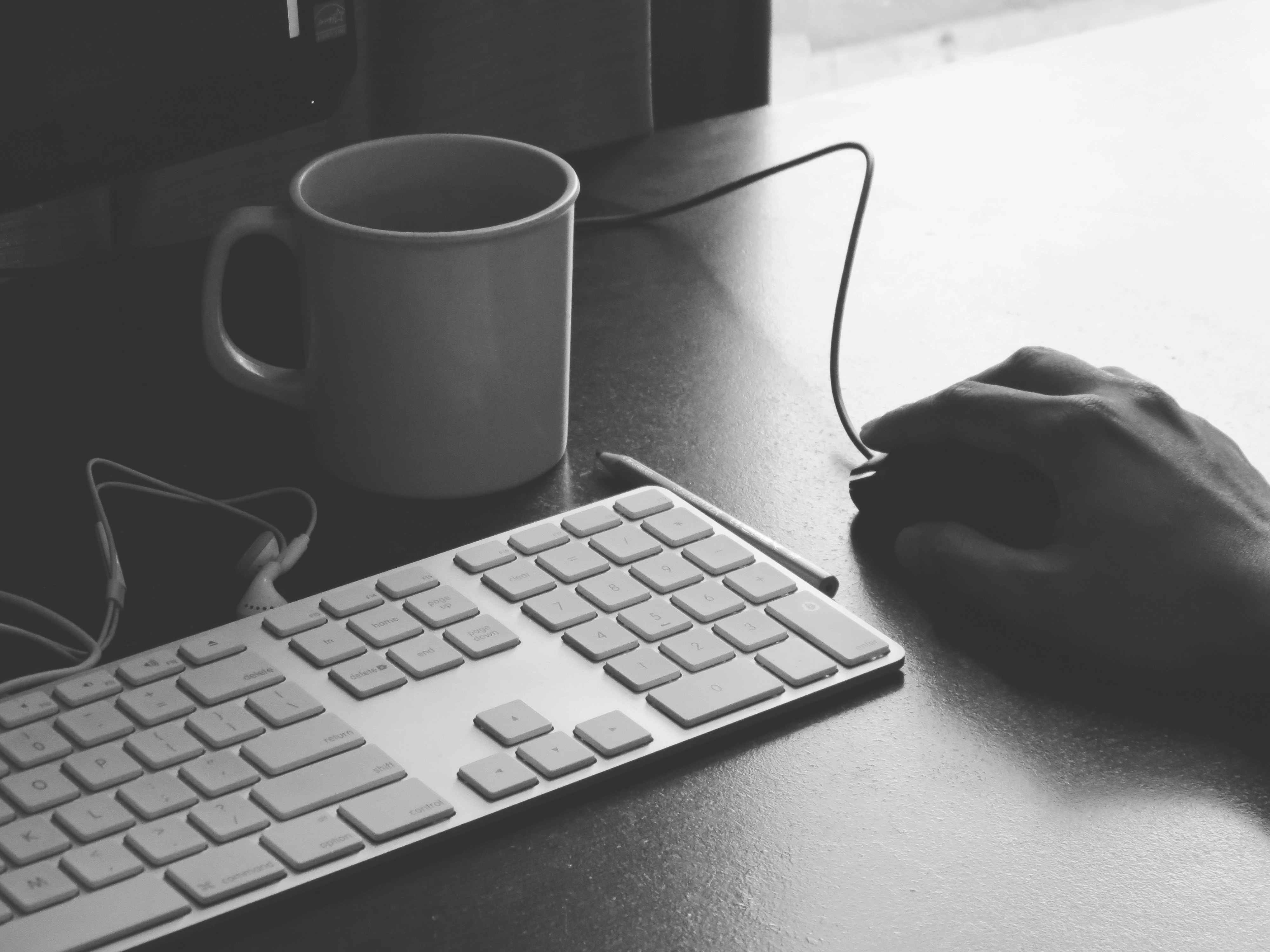Mac keyboard, mug, and hand using a mouse HD Wallpaper