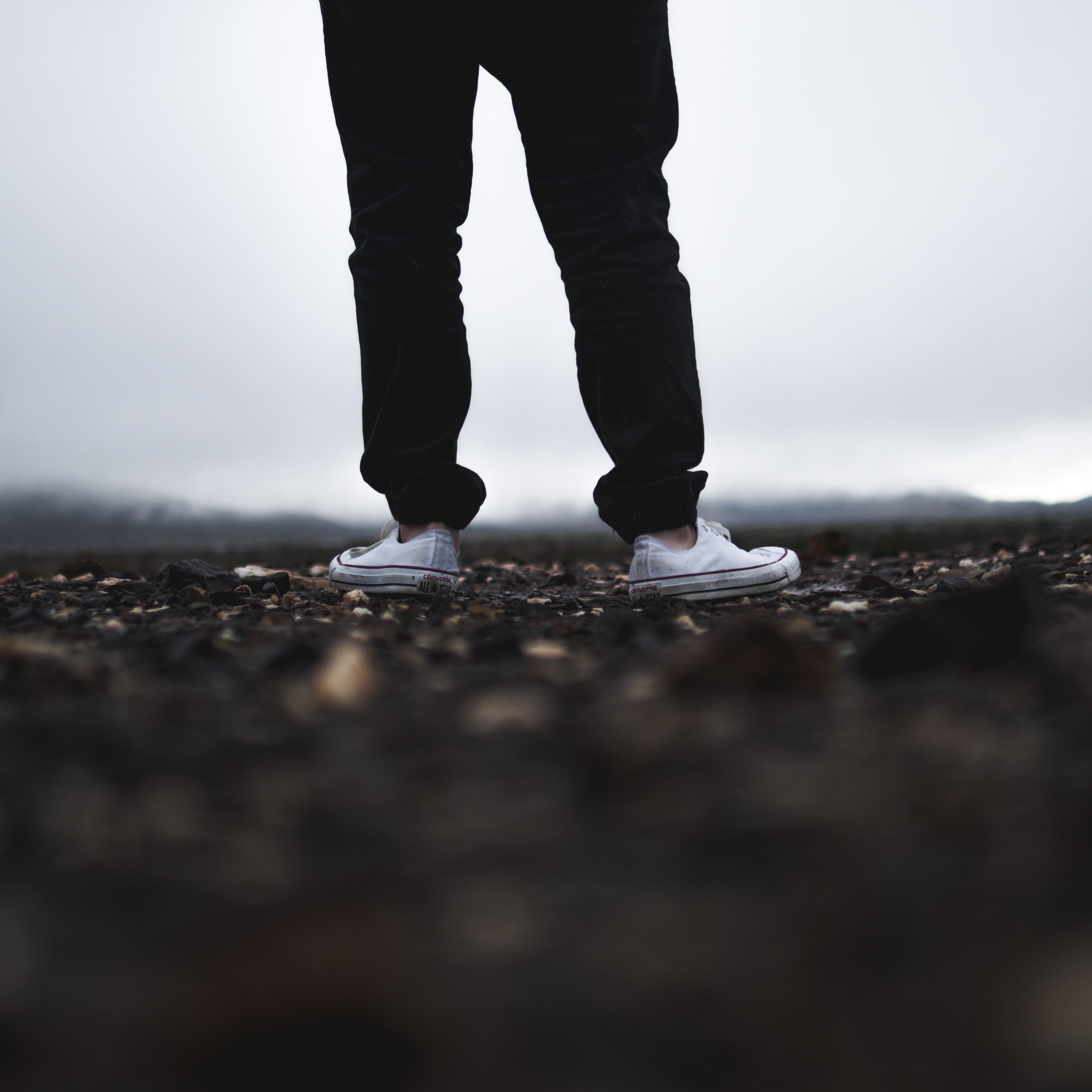 Man wearing black trousers and white Converse shoes HD Wallpaper