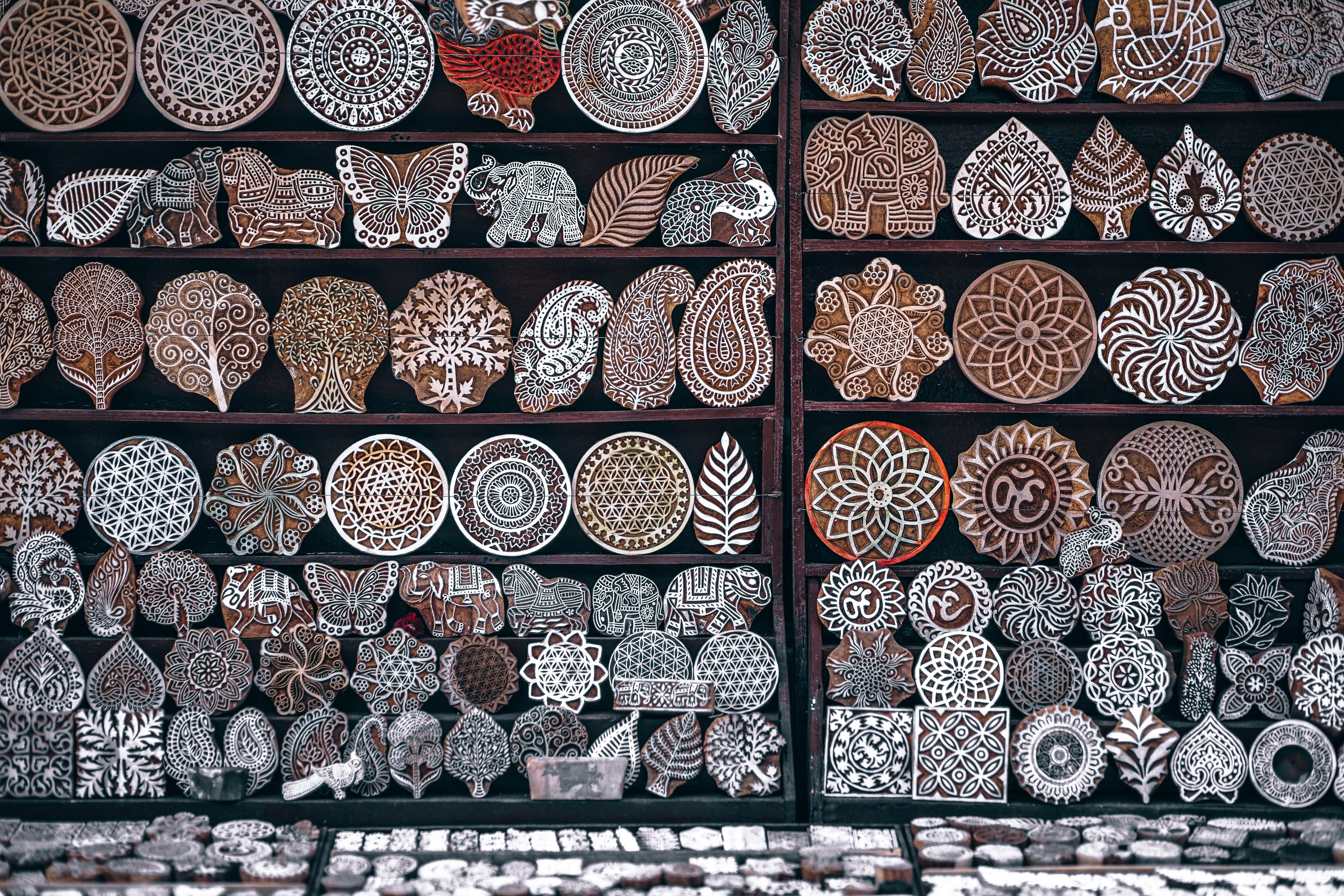 Handmade wooden stamps with traditional patterns at a market stall HD Wallpaper