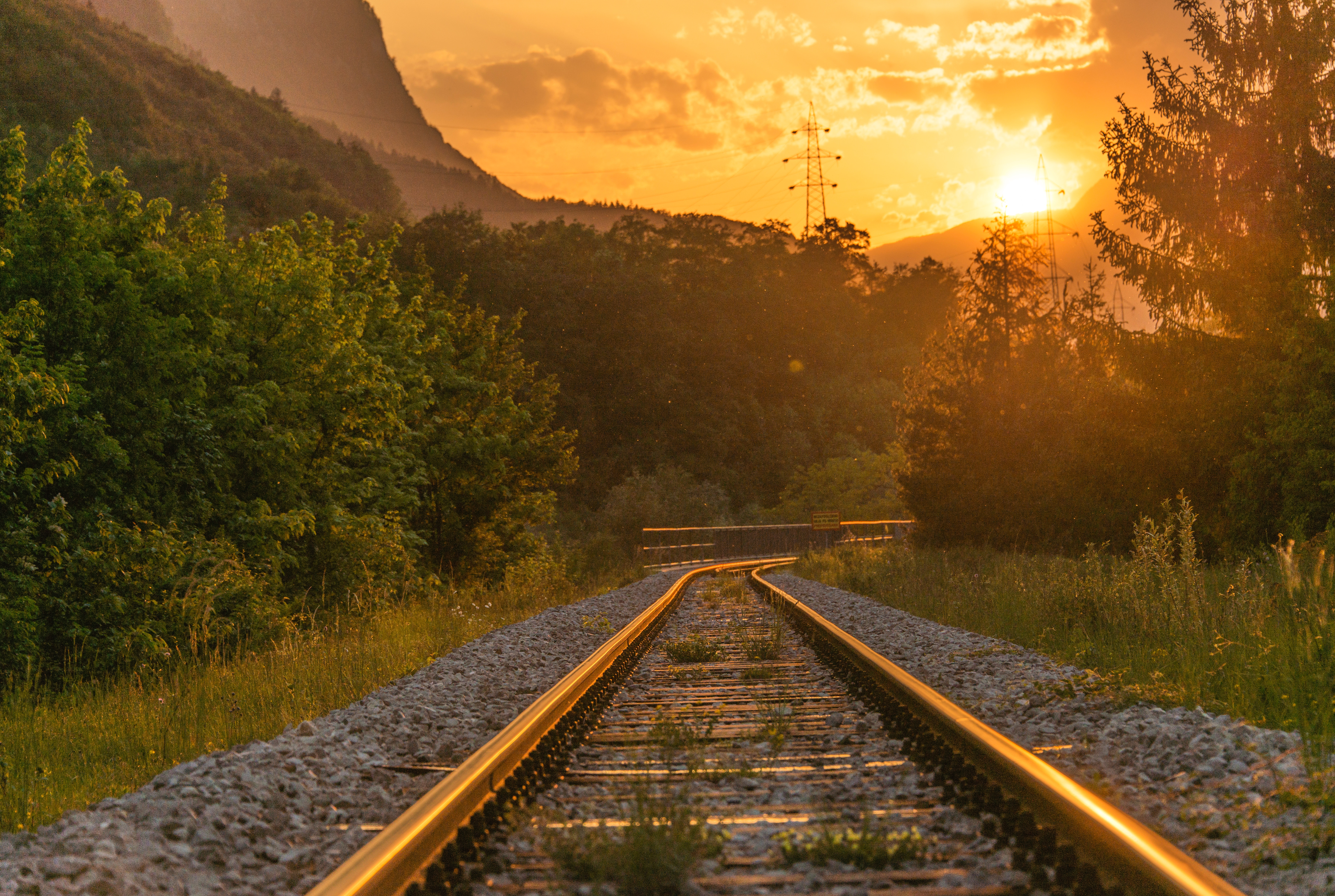 Sunset Over Railroad Tracks Through Forested Mountains HD Wallpaper