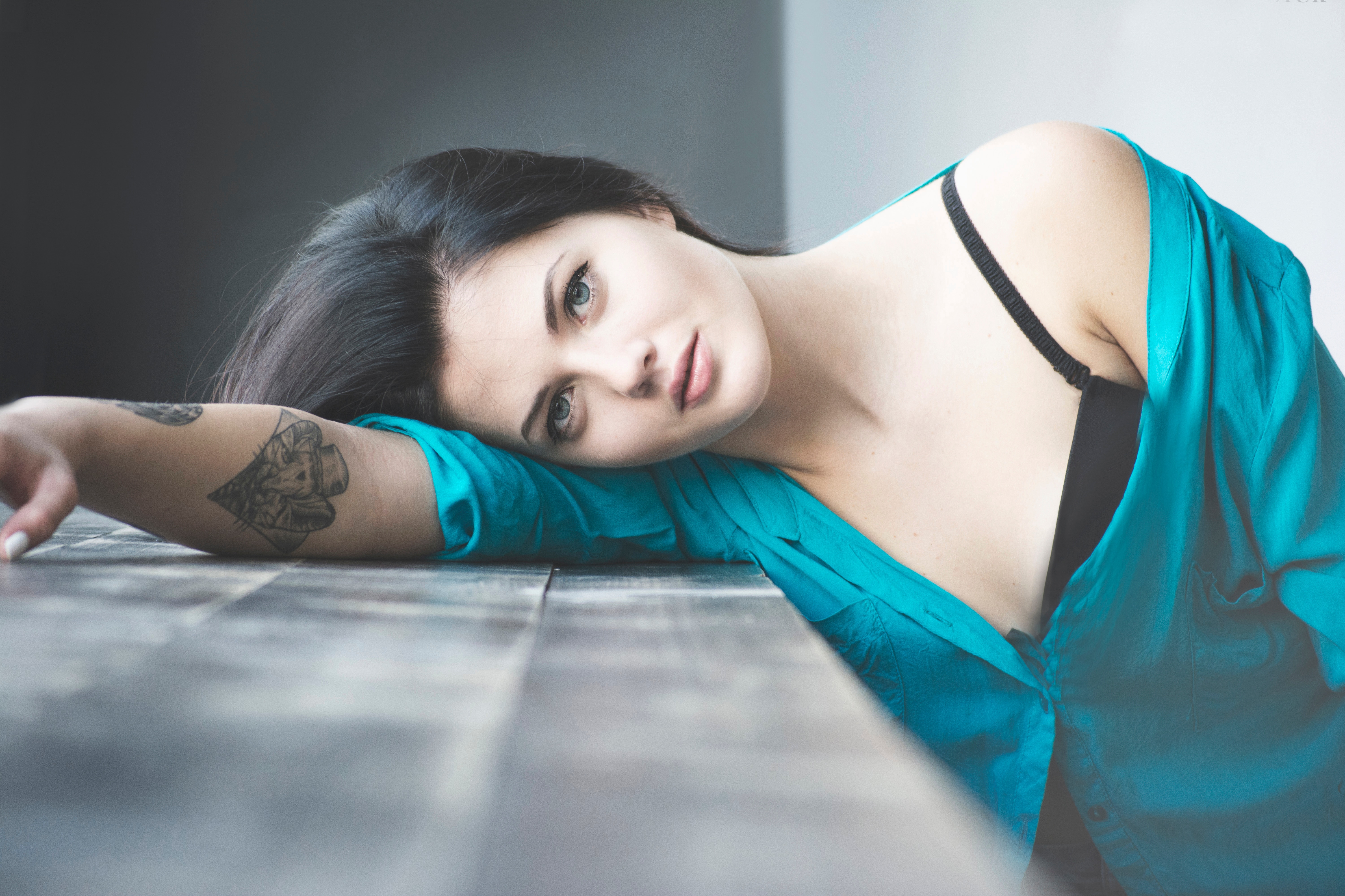 Woman with tattoo lying on wooden surface HD Wallpaper