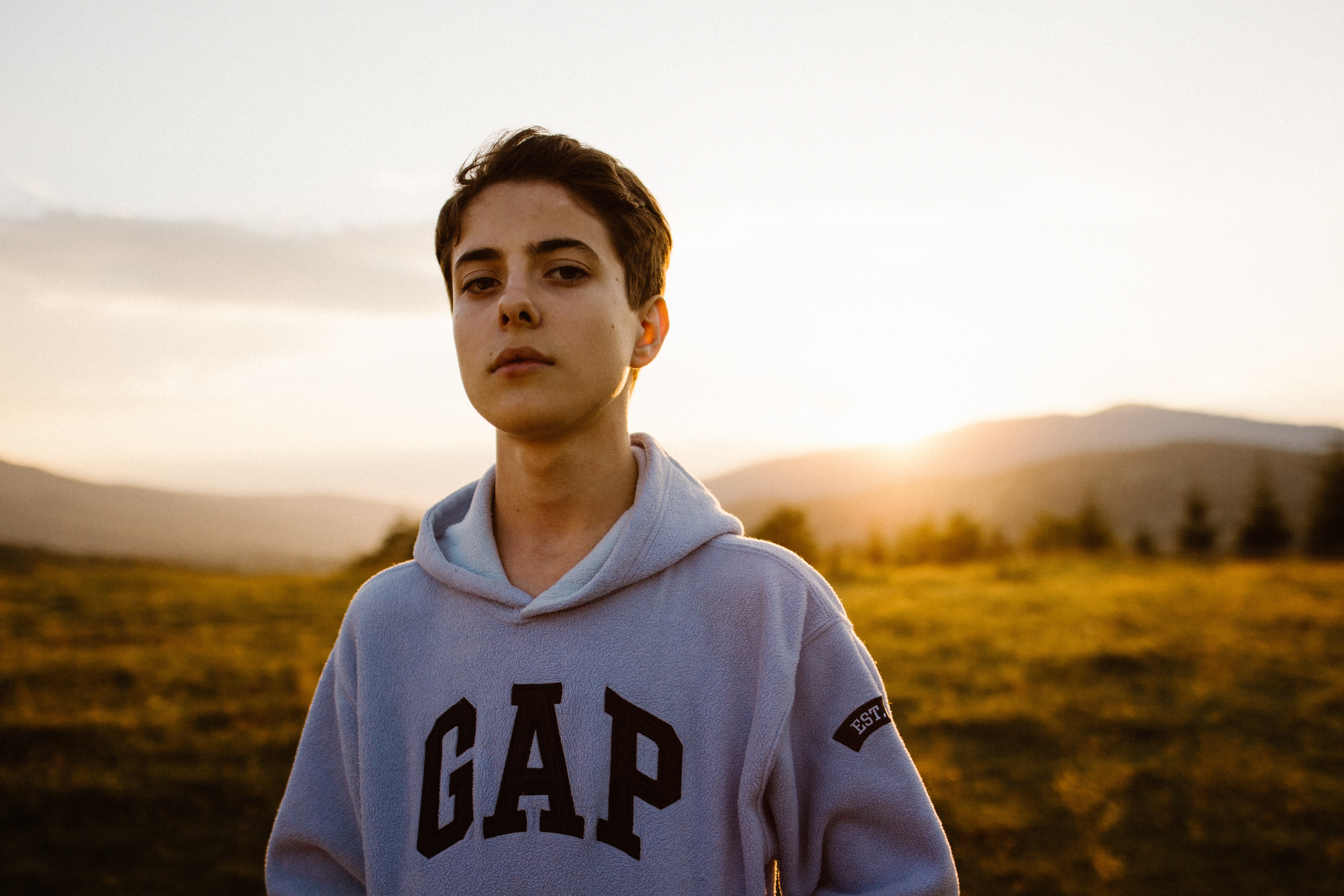 Boy wearing a Gap hoodie at sunset HD Wallpaper