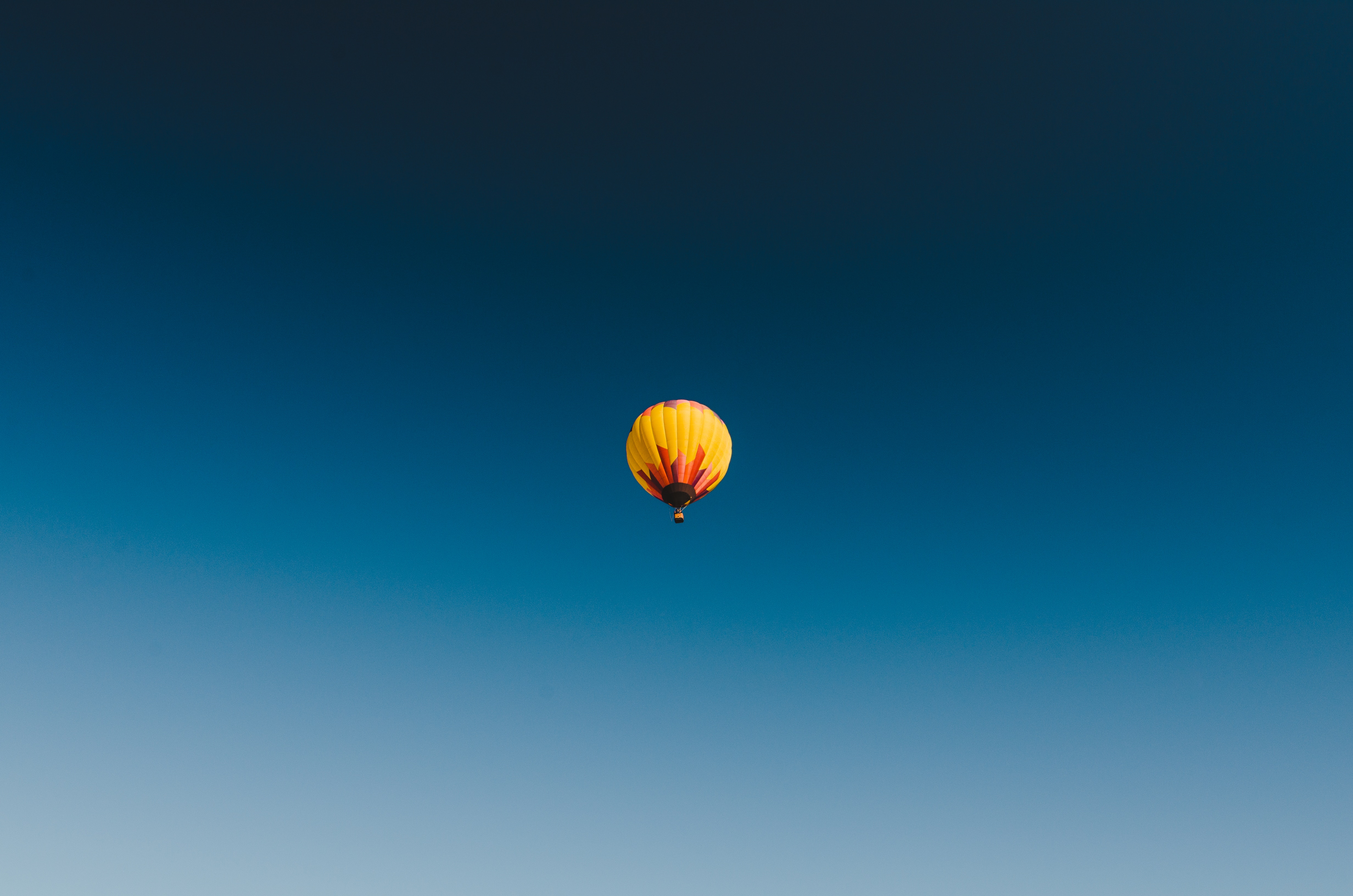 Hot air balloon floating in a clear blue sky HD Wallpaper