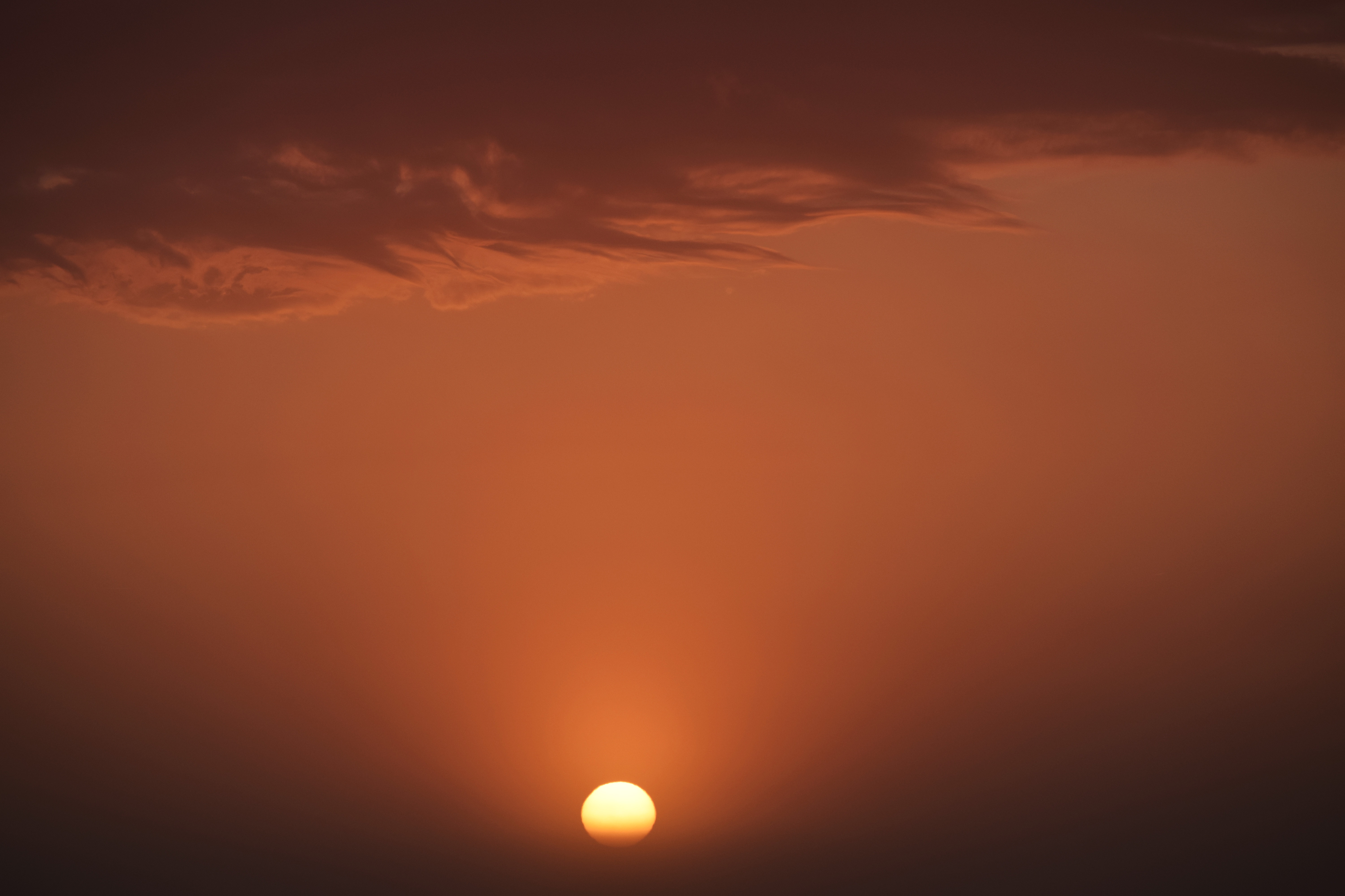 Sunset over a hazy orange sky with clouds HD Wallpaper
