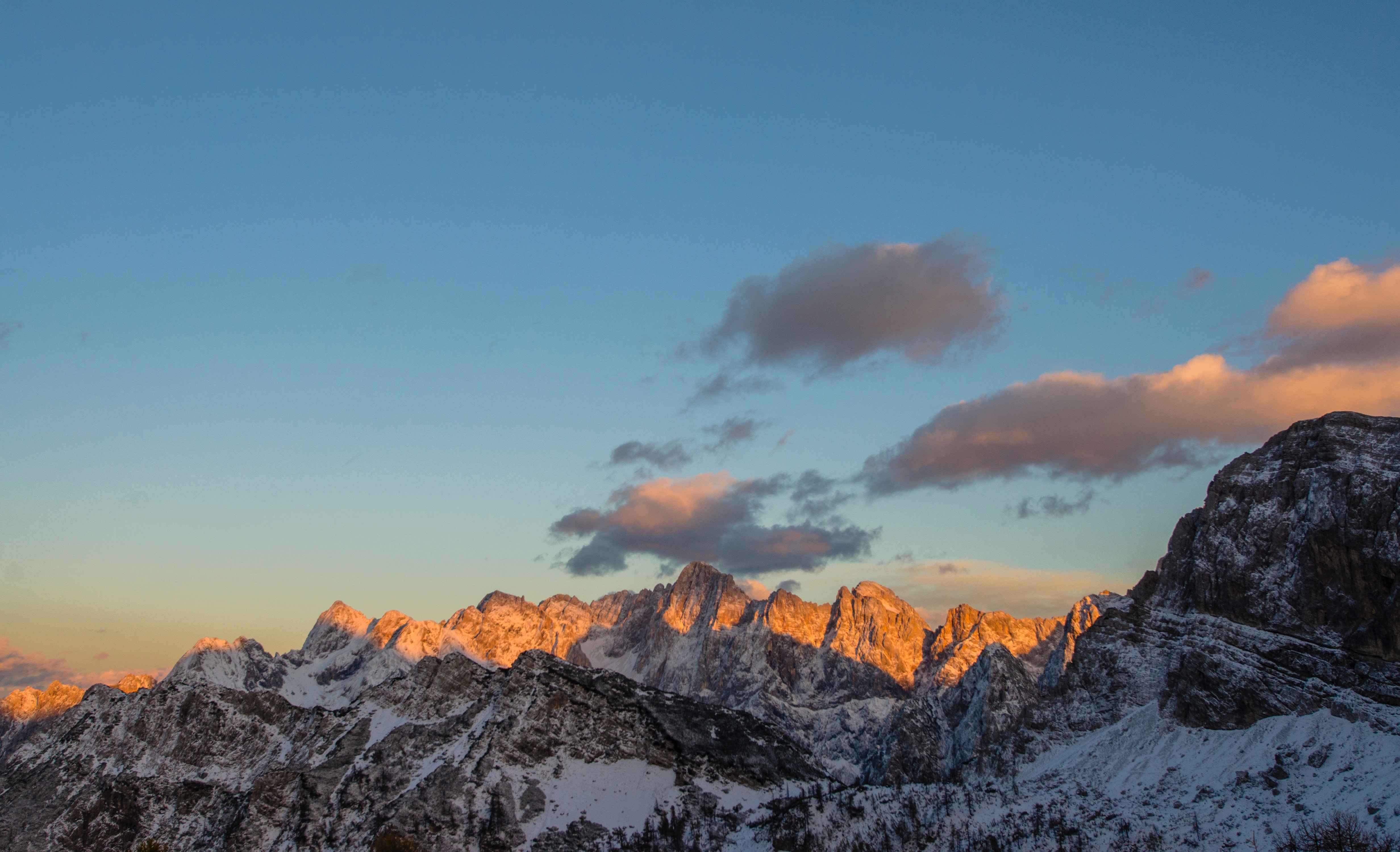 Snow-capped mountain range at sunset with clouds HD Wallpaper