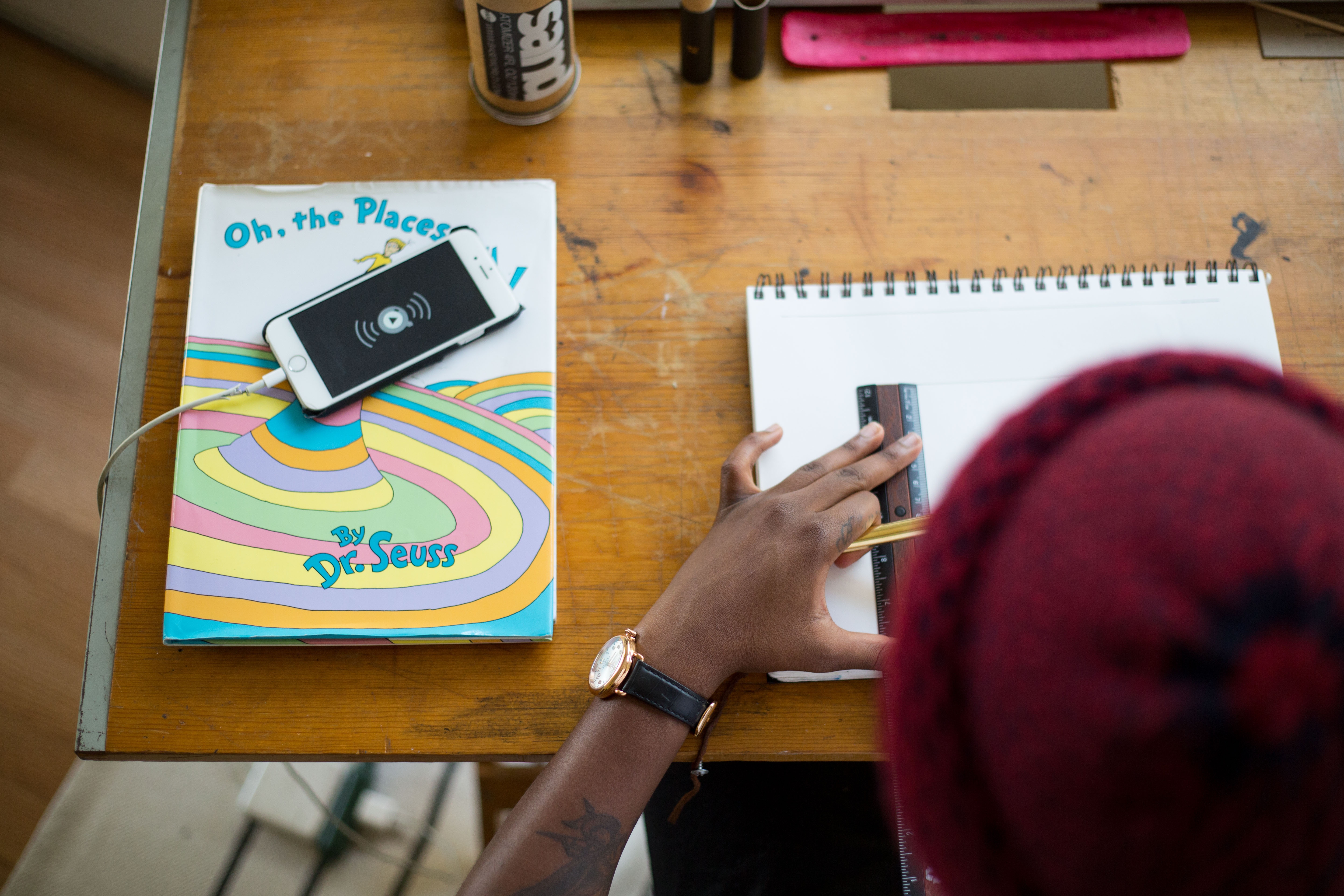 Person drawing with Dr. Seuss book and iPhone HD Wallpaper