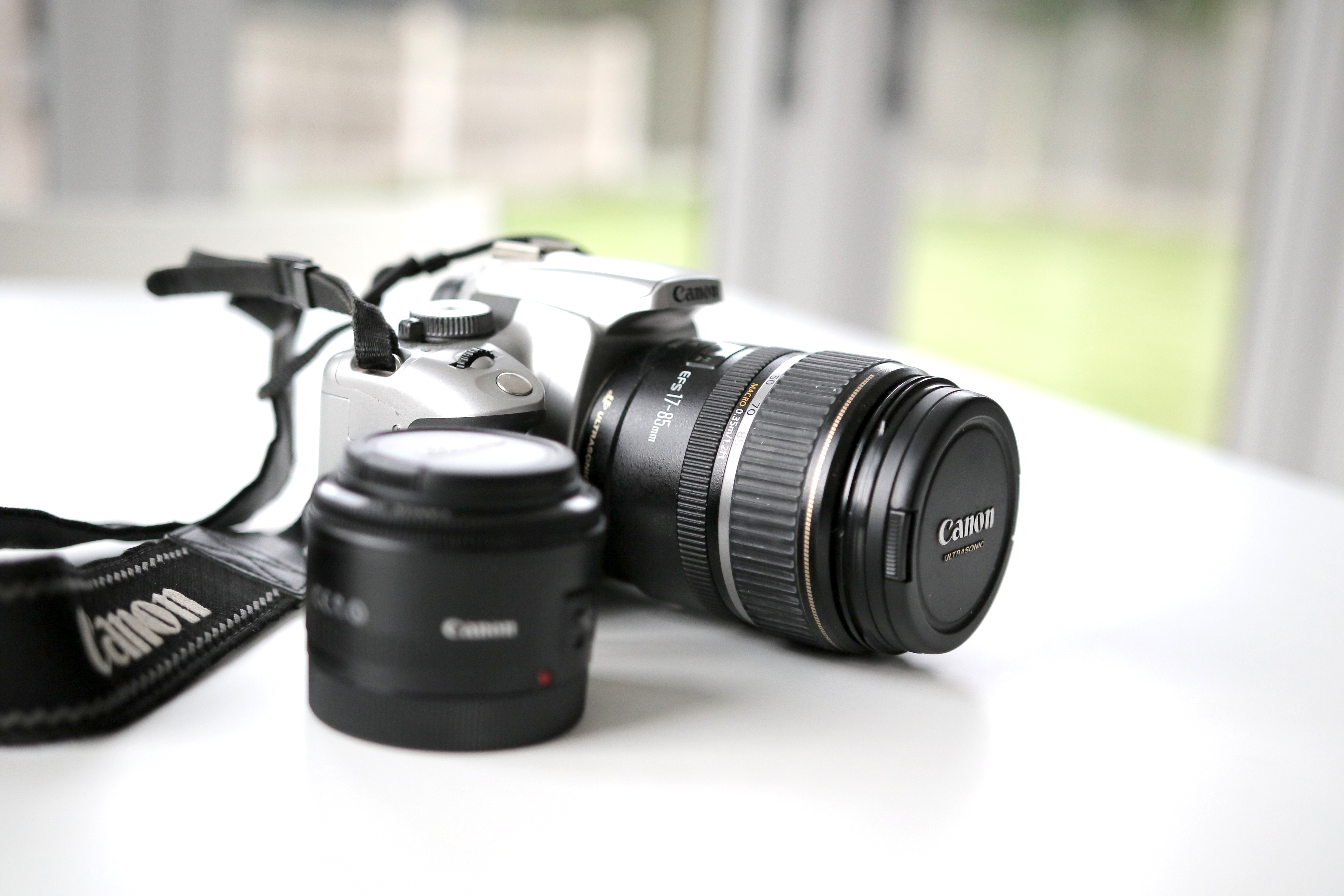 Canon DSLR camera with two lenses and strap HD Wallpaper