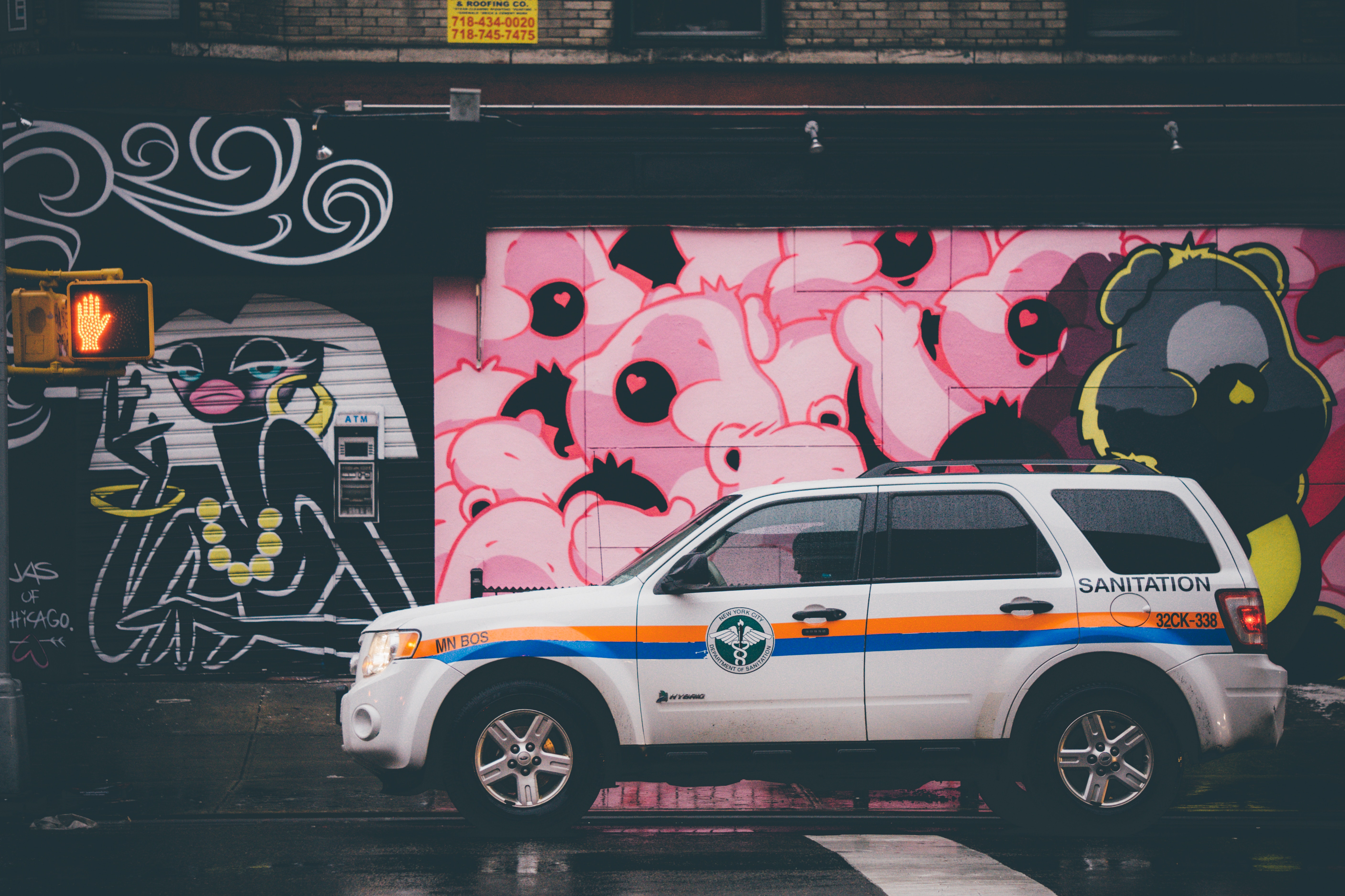 Sanitation vehicle parked in front of graffiti art HD Wallpaper