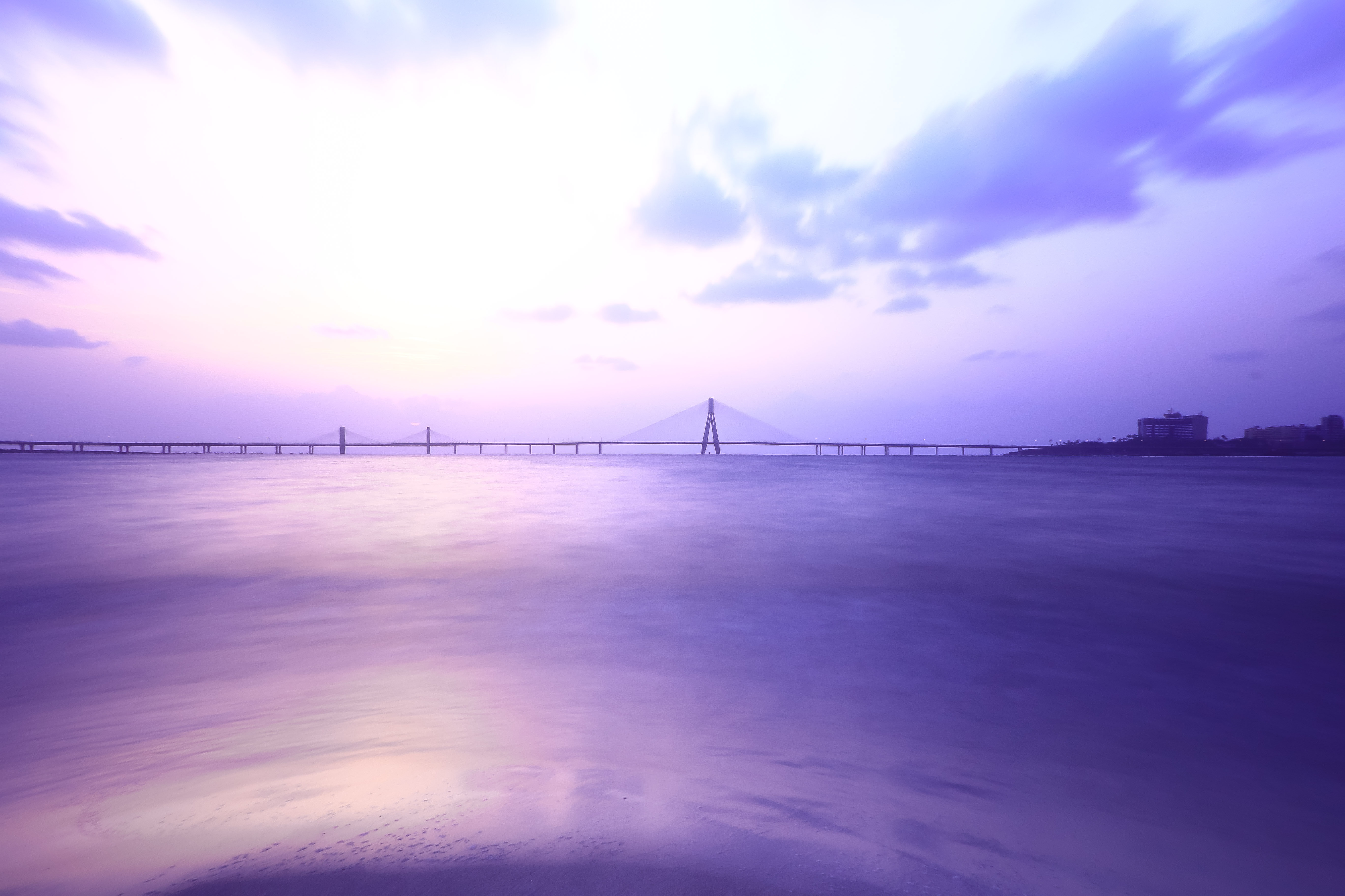 Purple sunset over a long bridge and calm water HD Wallpaper