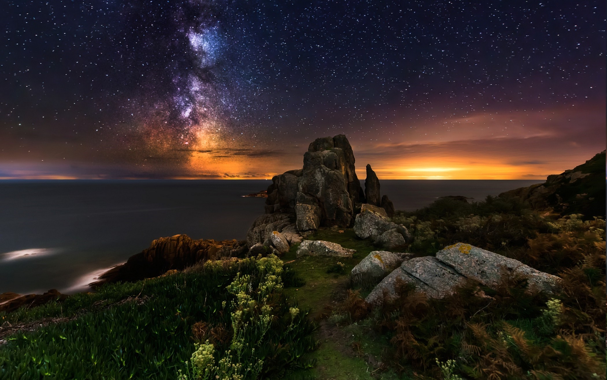 Milky Way over rocky coast and sea at night HD Wallpaper