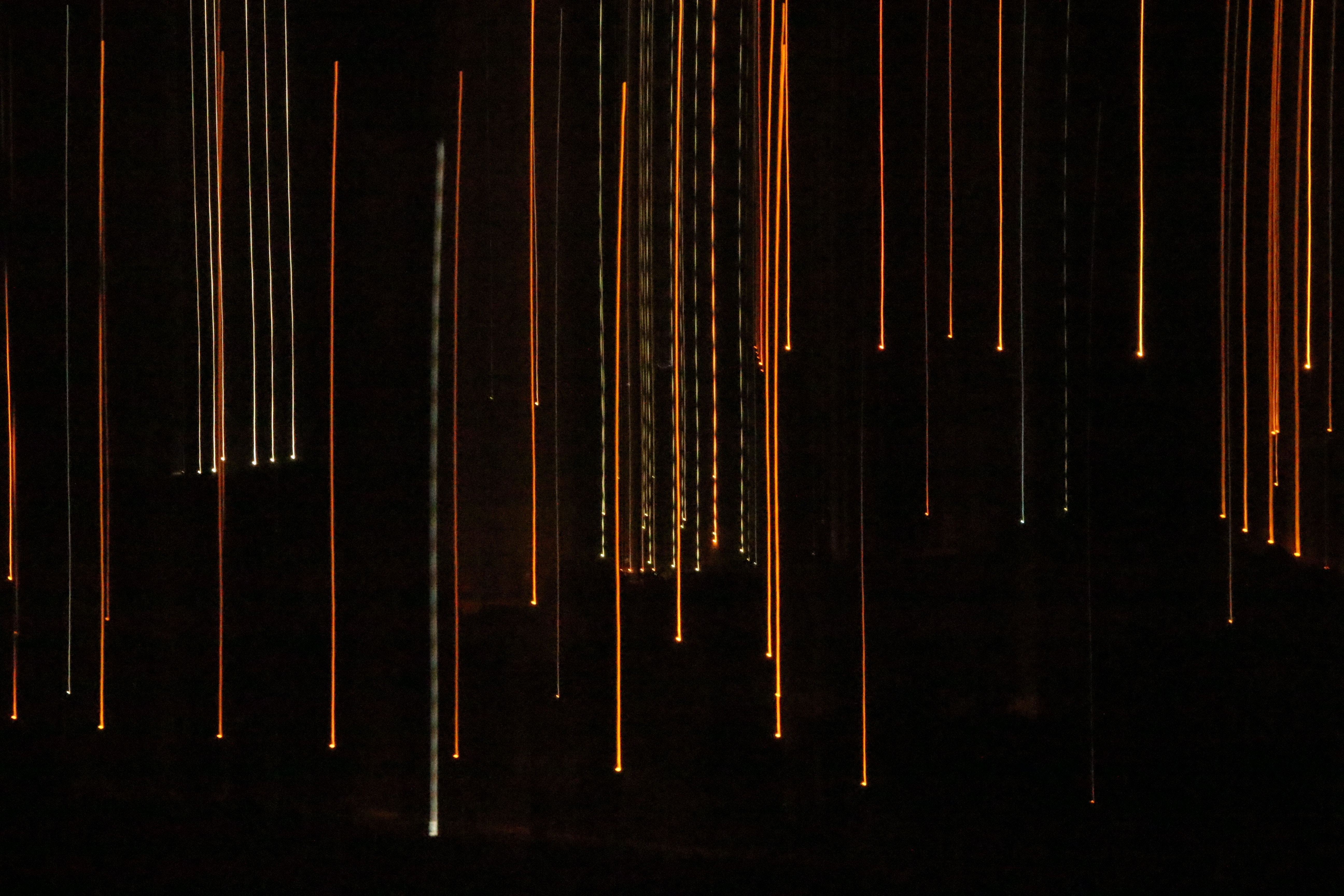 Orange and white light streaks against black background HD Wallpaper