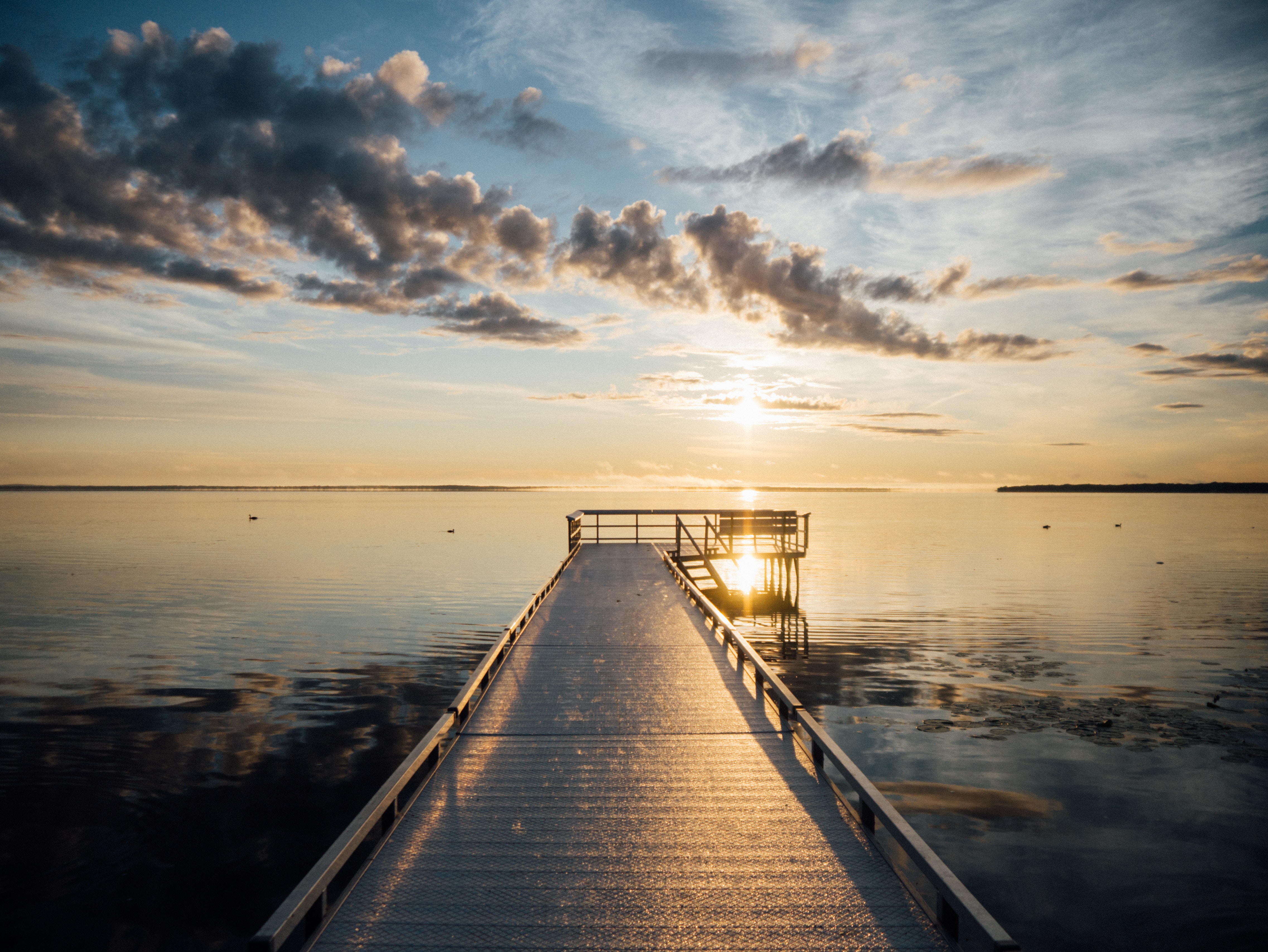 Sunrise over a calm lake with a wooden pier HD Wallpaper