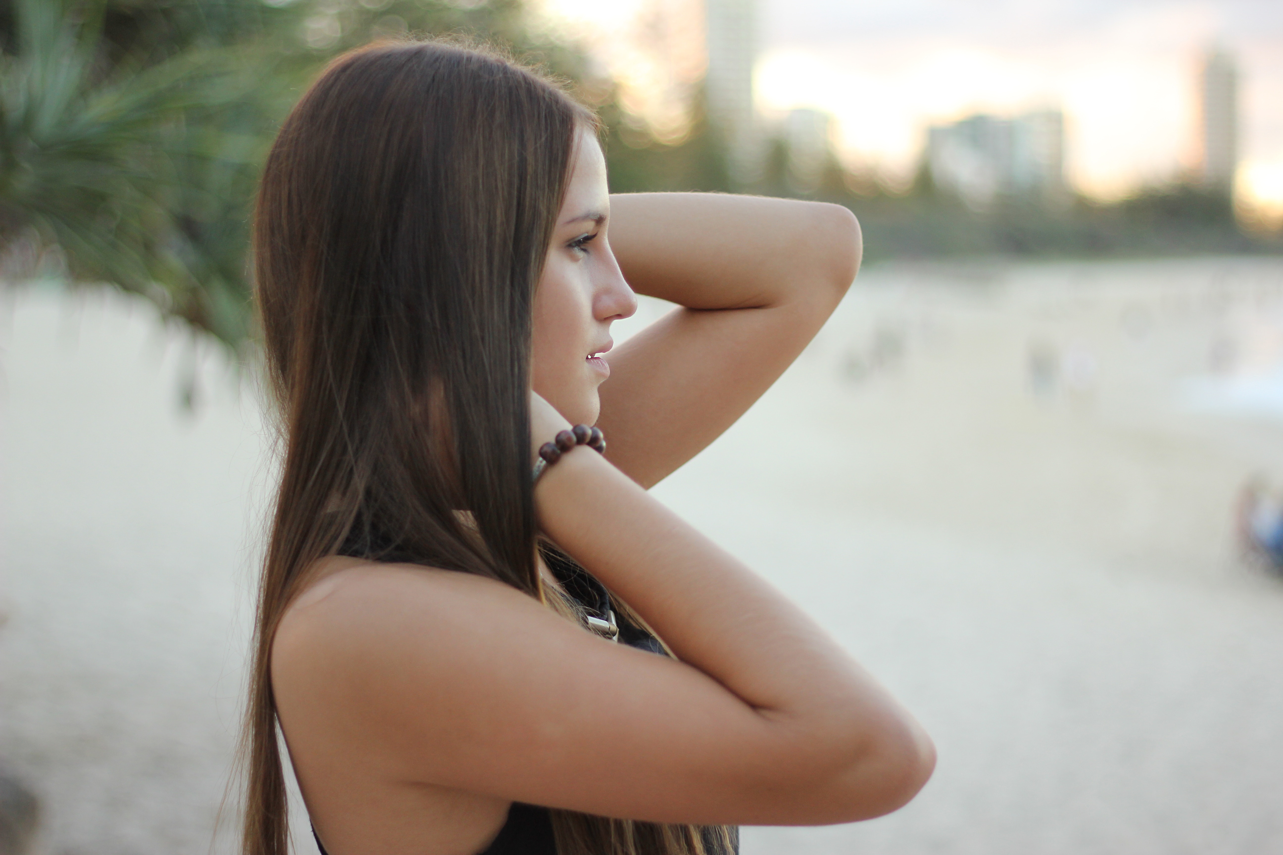 Woman with long brown hair on a beach at sunset HD Wallpaper