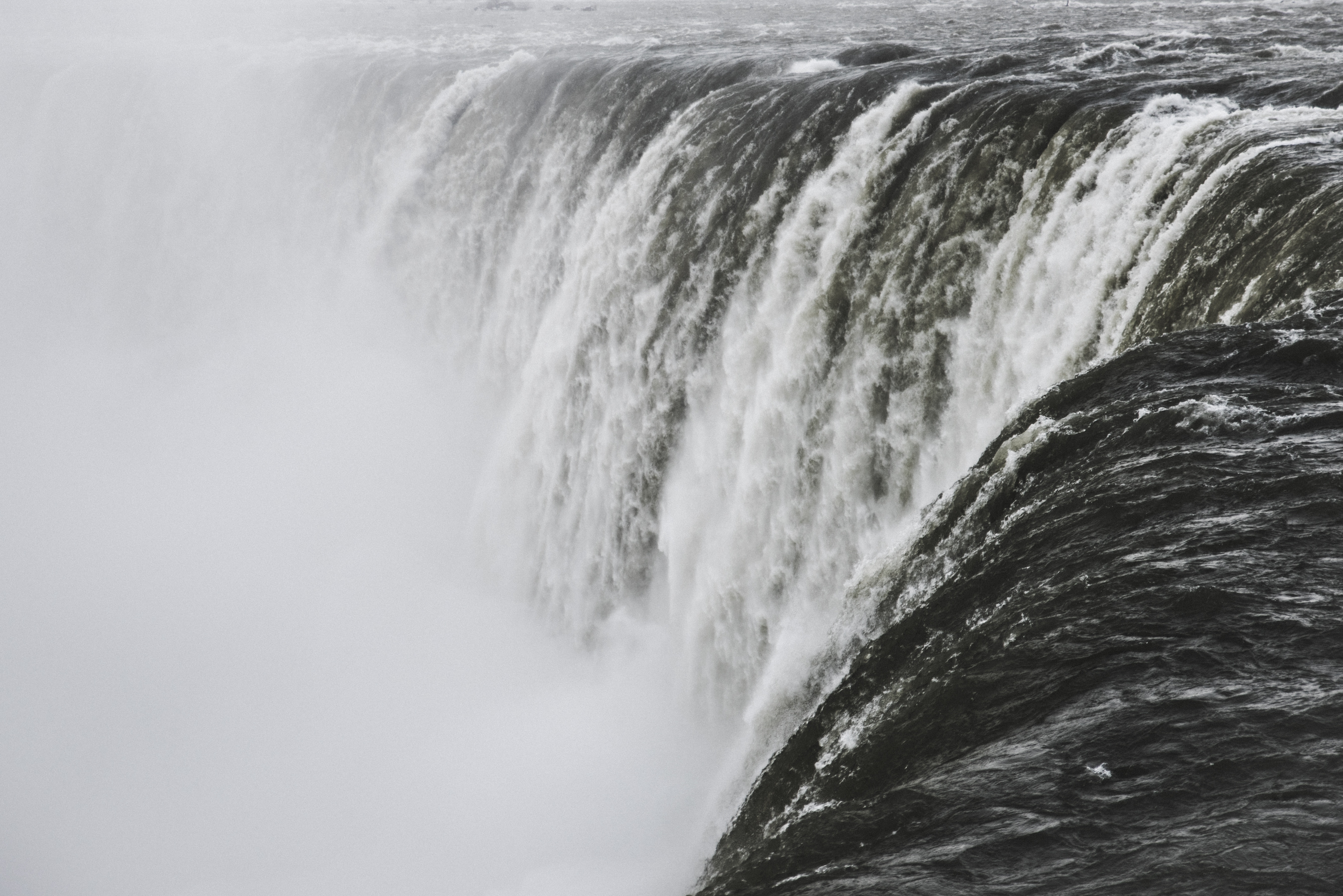 Powerful waterfall cascading into misty abyss HD Wallpaper