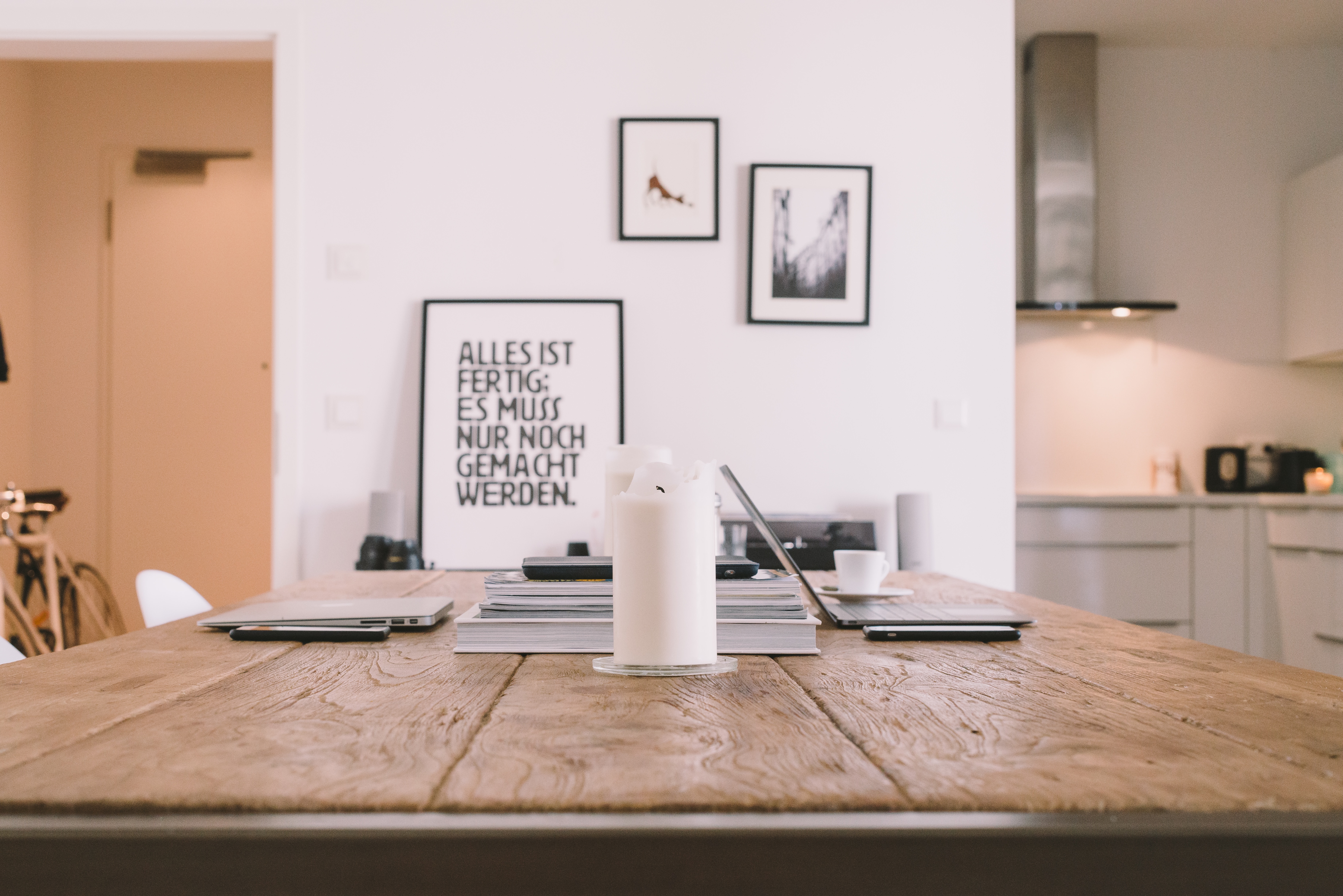 Dining table with laptops, candle, and framed art HD Wallpaper