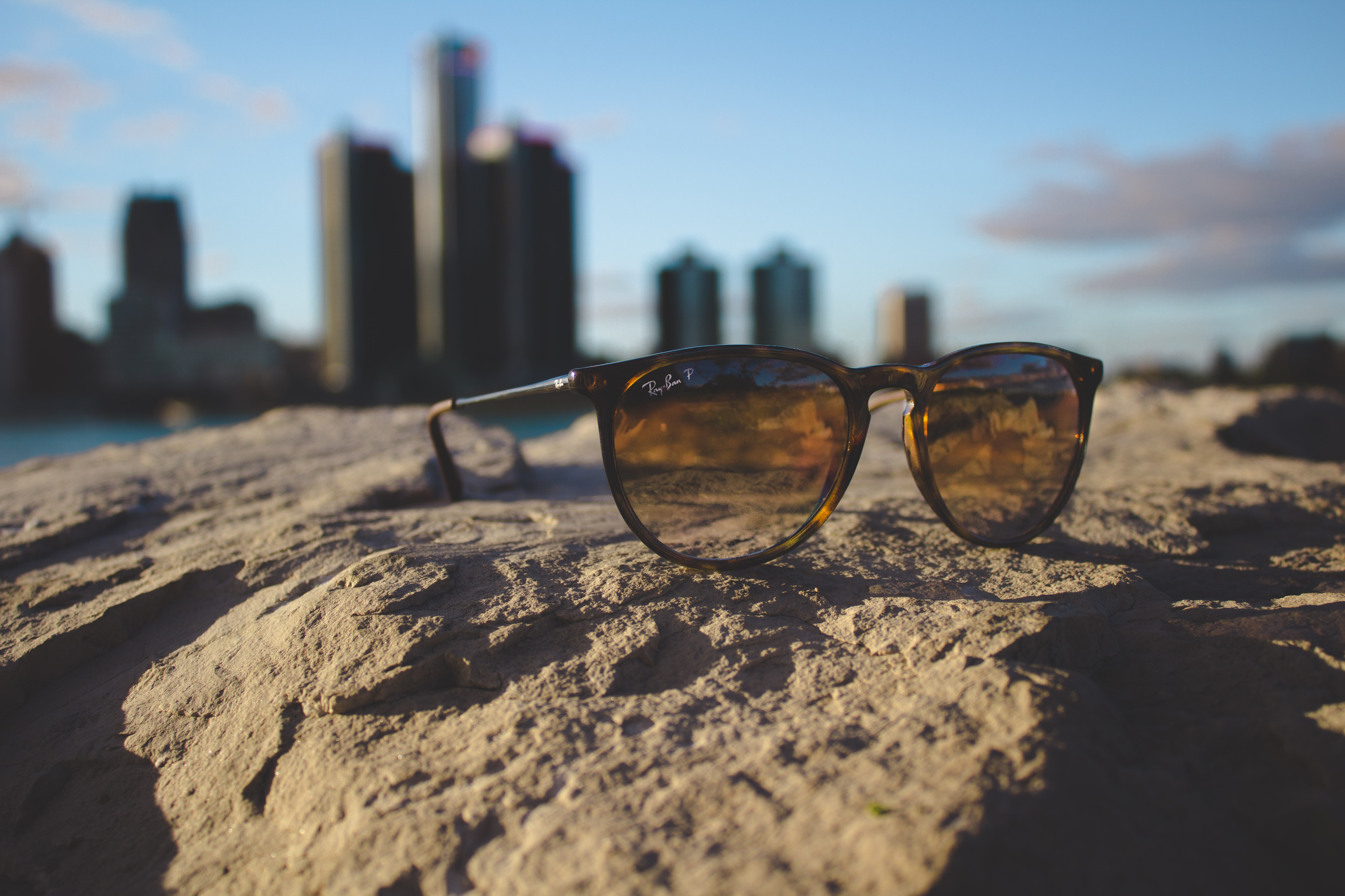 Ray-Ban sunglasses on a rock with Detroit skyline HD Wallpaper