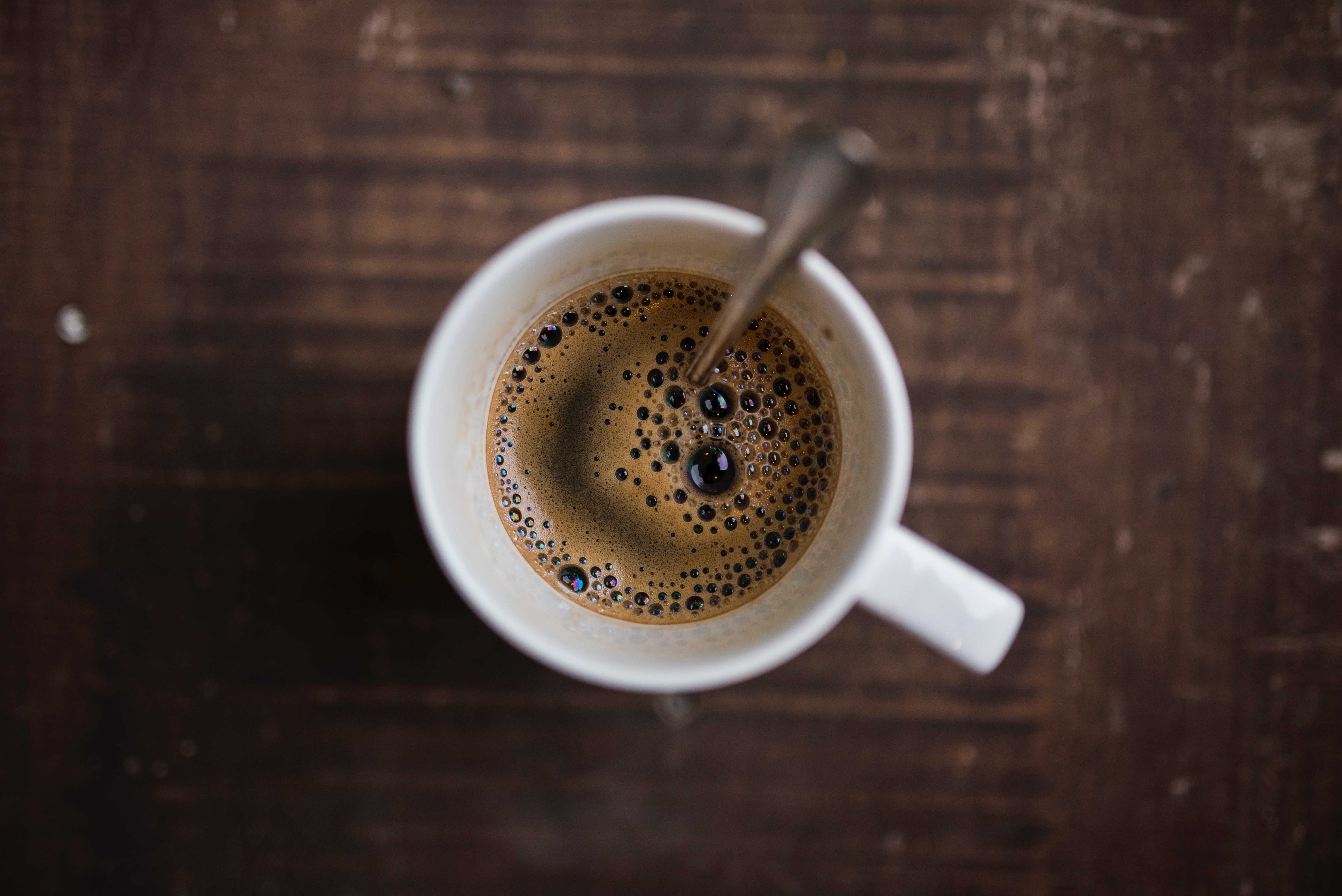 Top-down view of coffee in a mug with a spoon HD Wallpaper