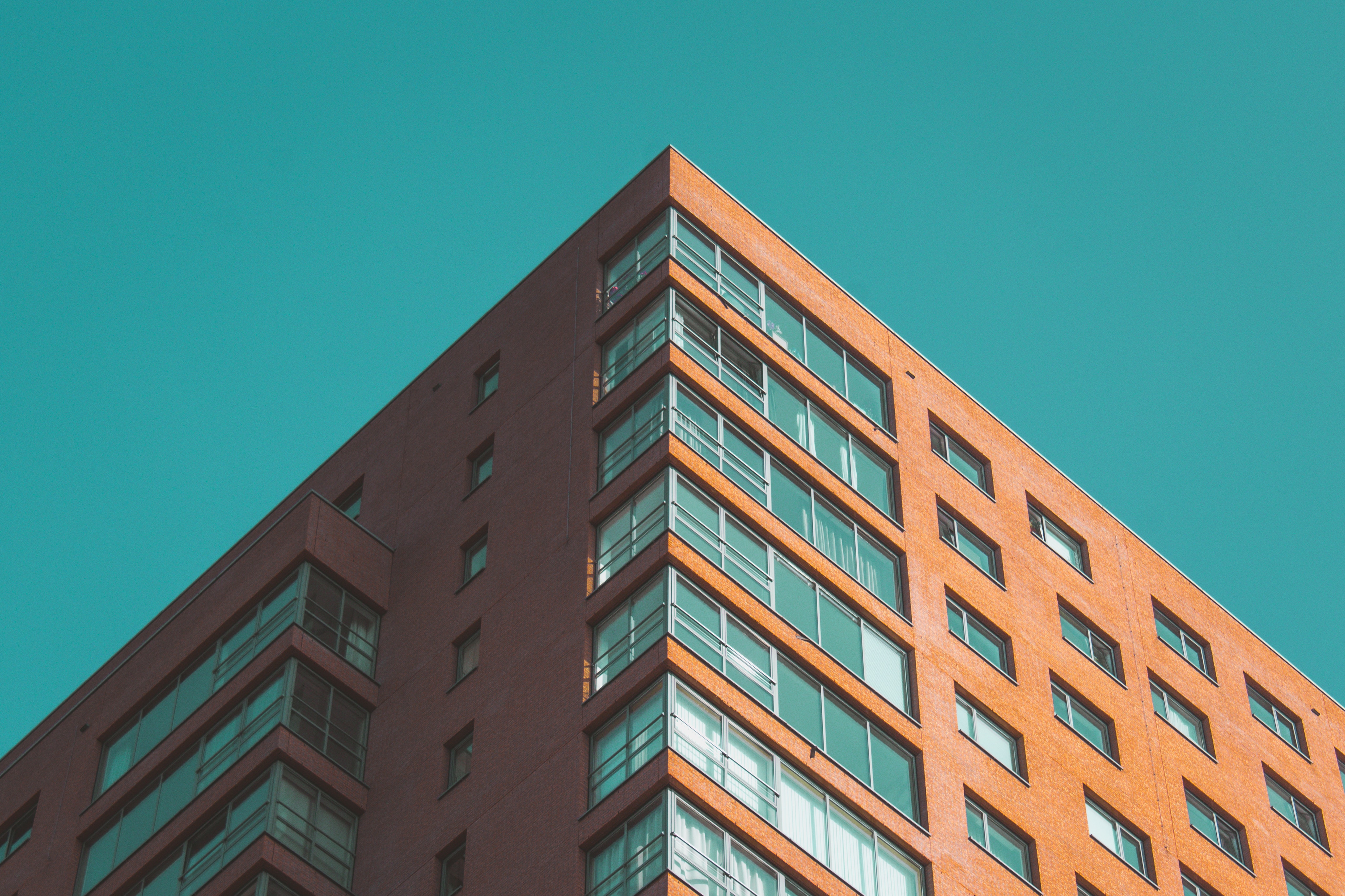 Orange building with geometric windows against blue sky HD Wallpaper