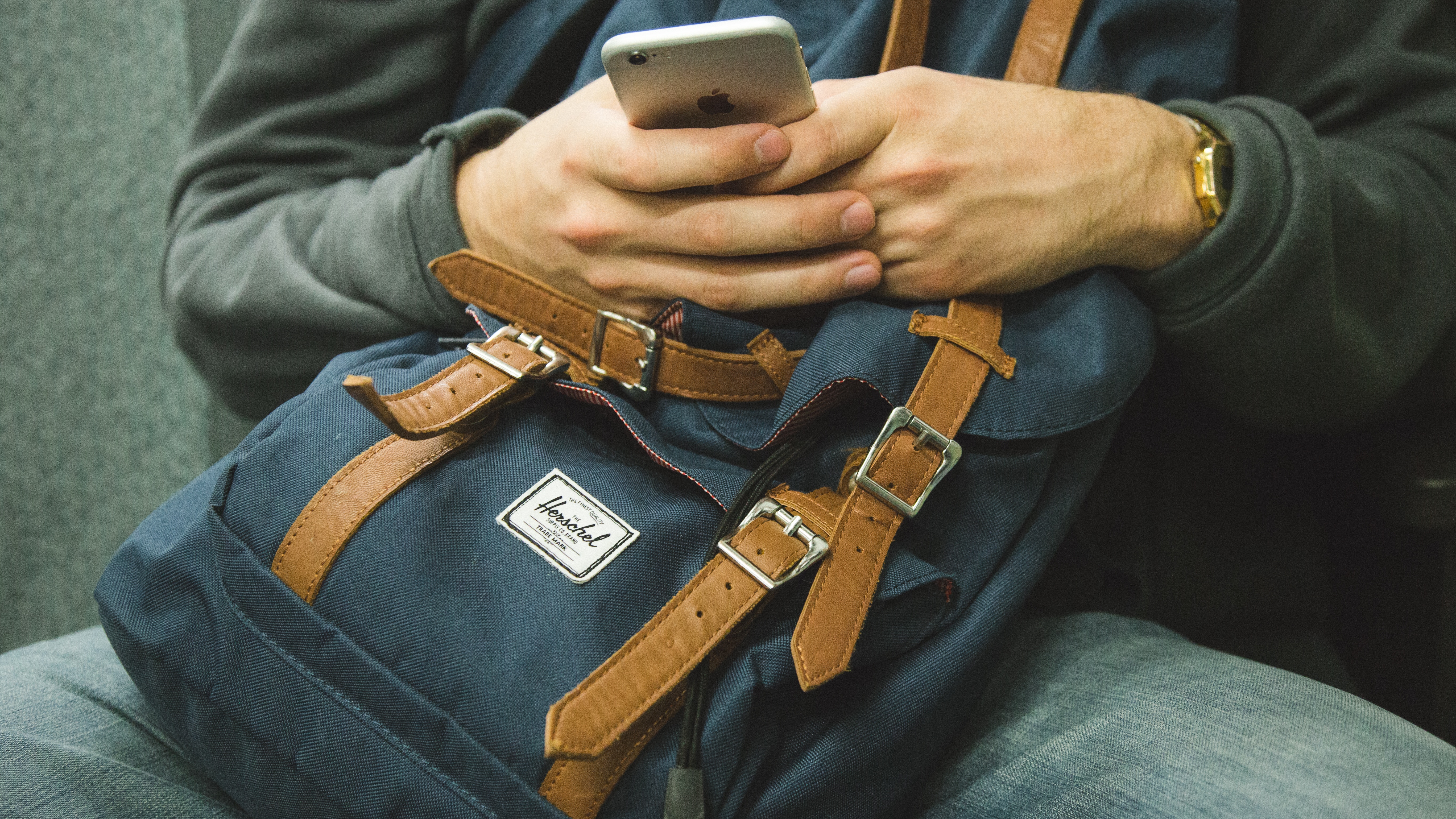 Man using iPhone with Herschel backpack HD Wallpaper