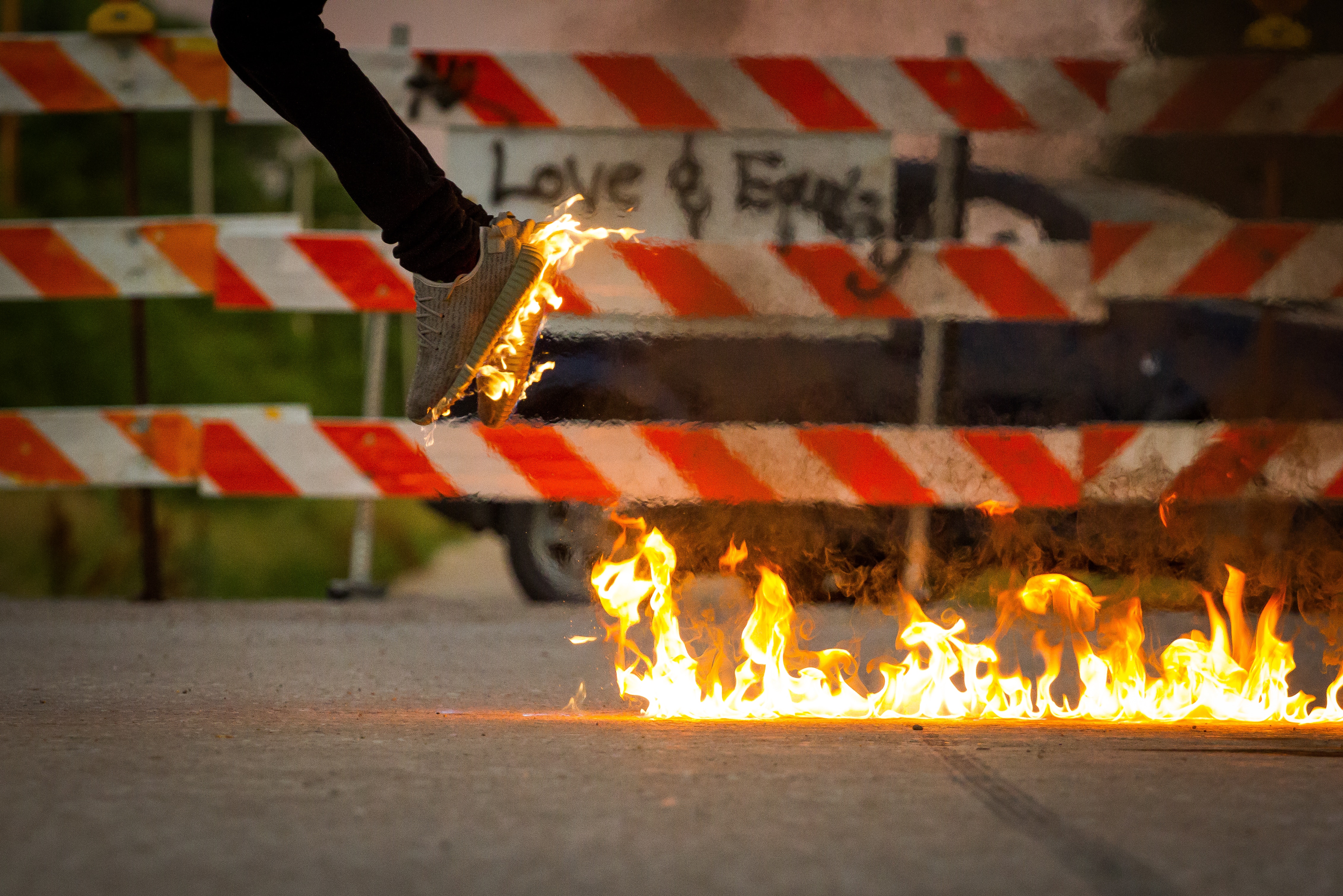 Person jumping over fire near barricade HD Wallpaper