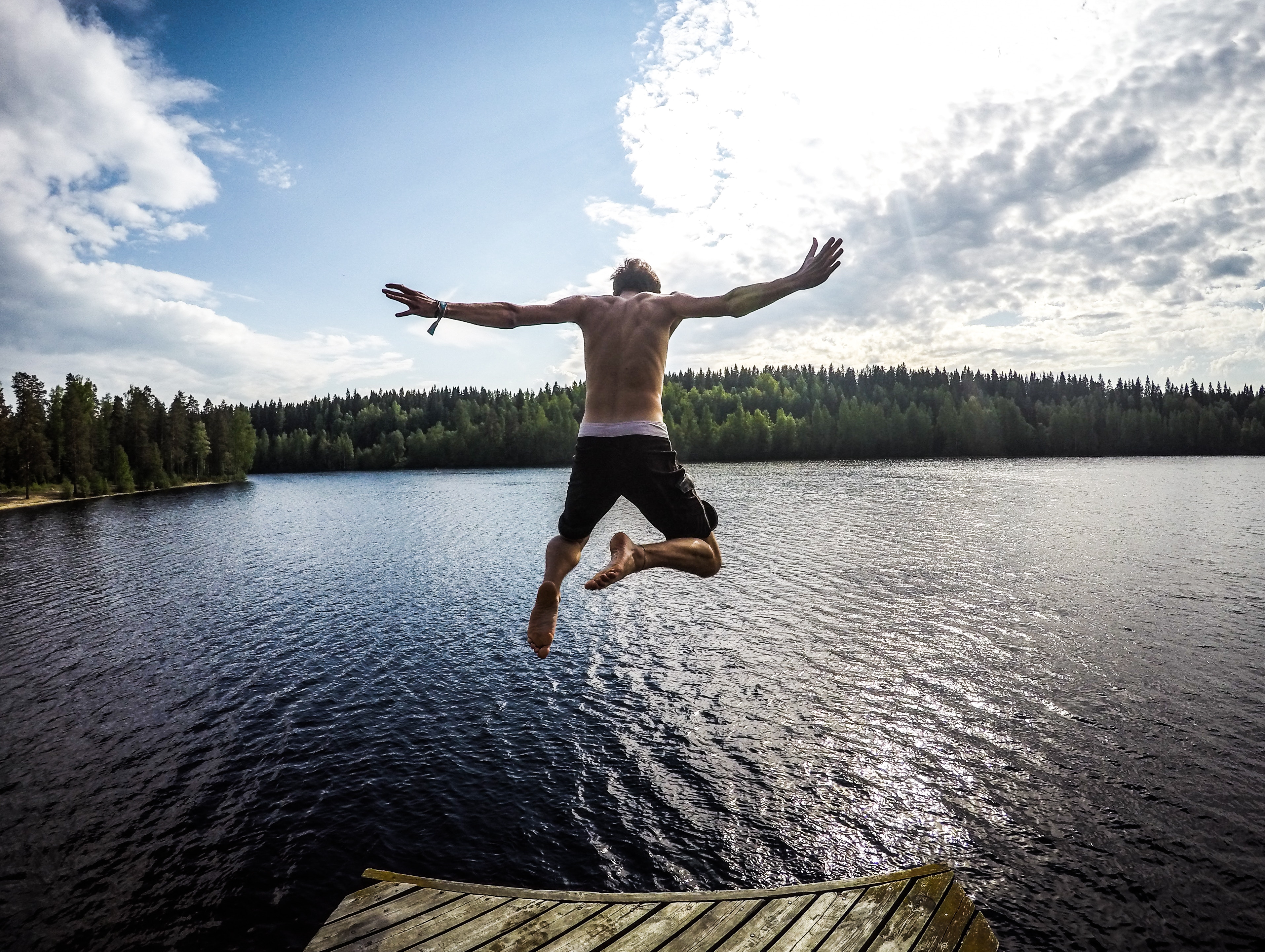 Man jumping into a lake in Finland HD Wallpaper
