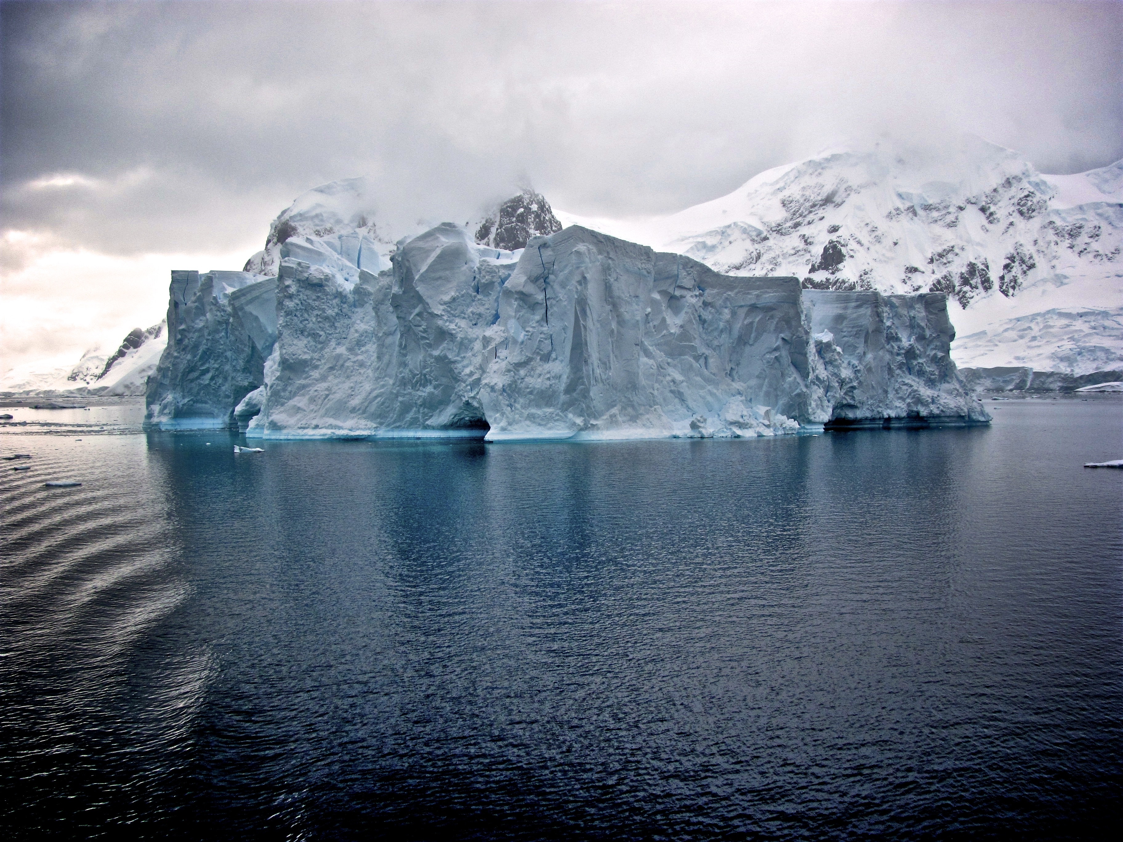 Iceberg in Antarctica with Snowy Mountains HD Wallpaper