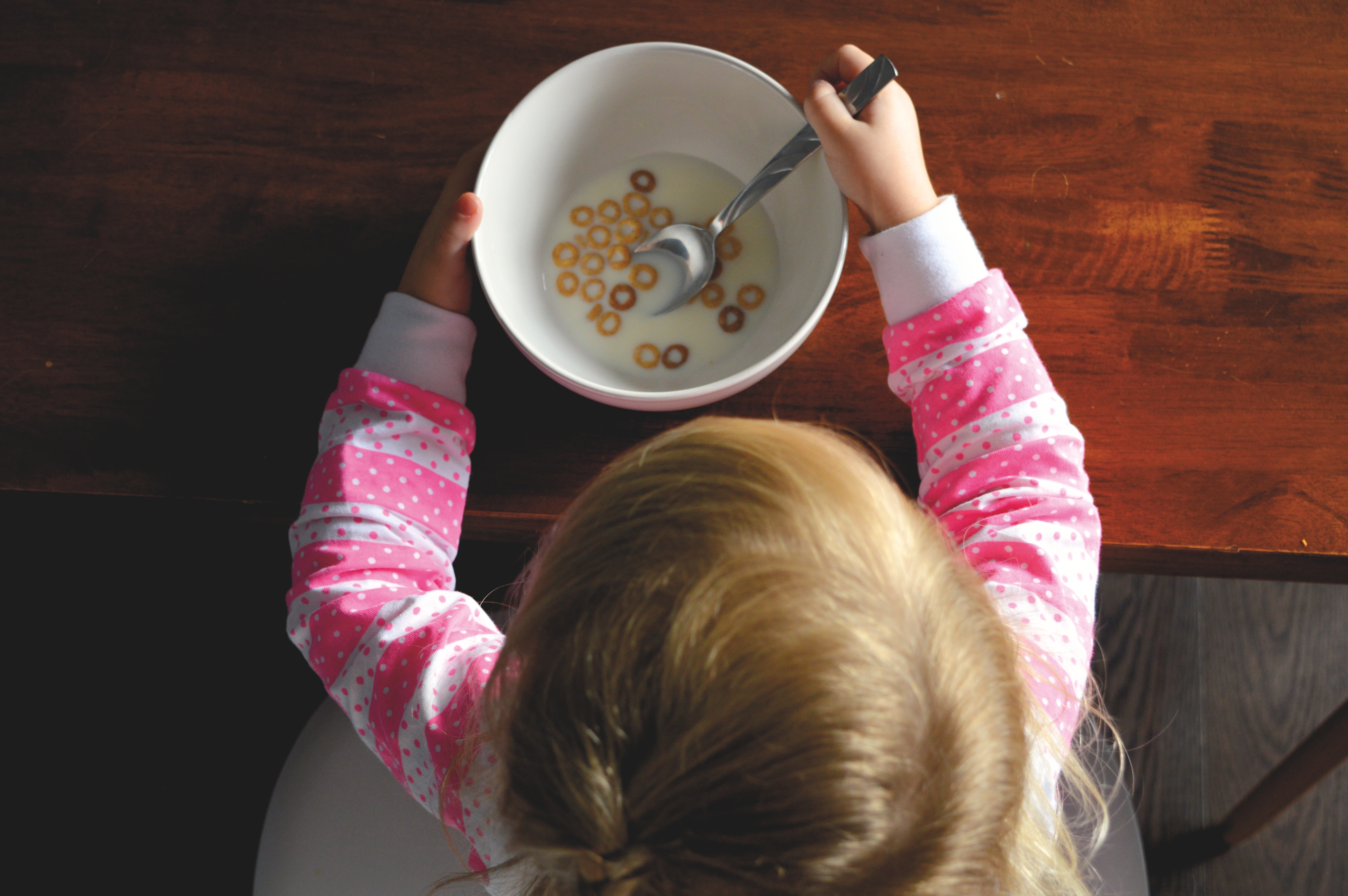 Child eating cereal with a spoon HD Wallpaper