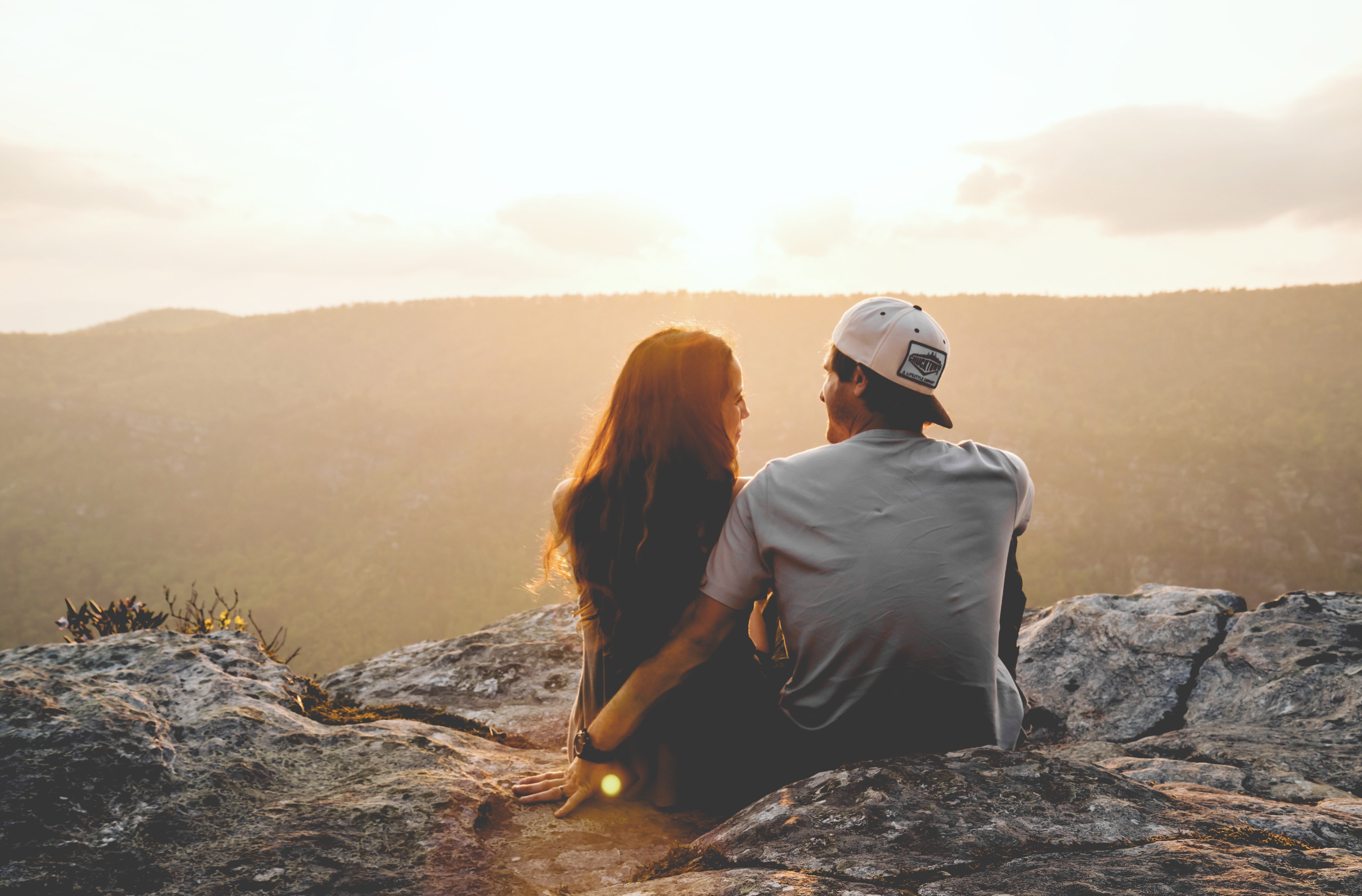 Couple sitting on a cliff at sunset in North Carolina HD Wallpaper