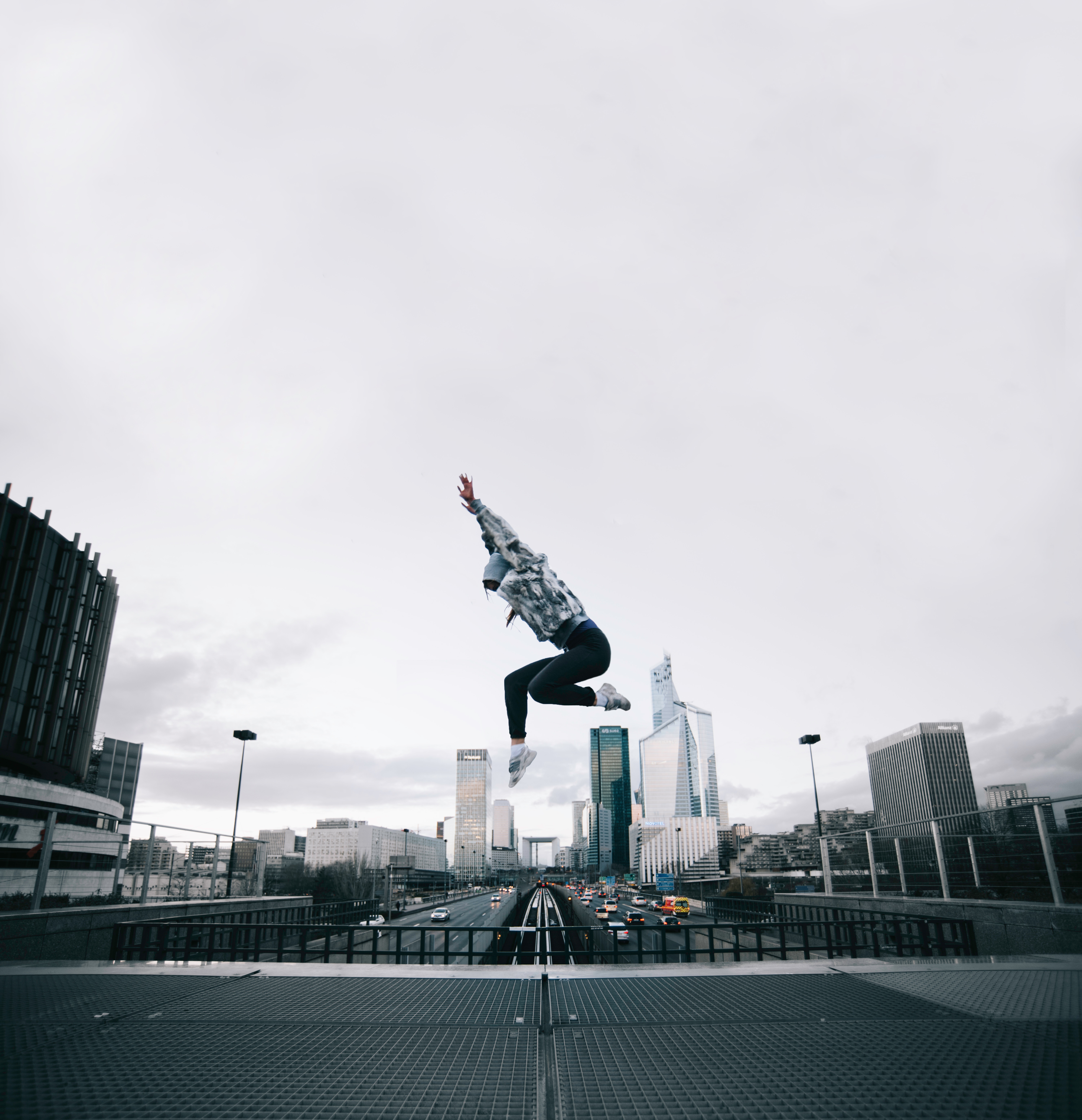 Person jumping over a highway in a city HD Wallpaper