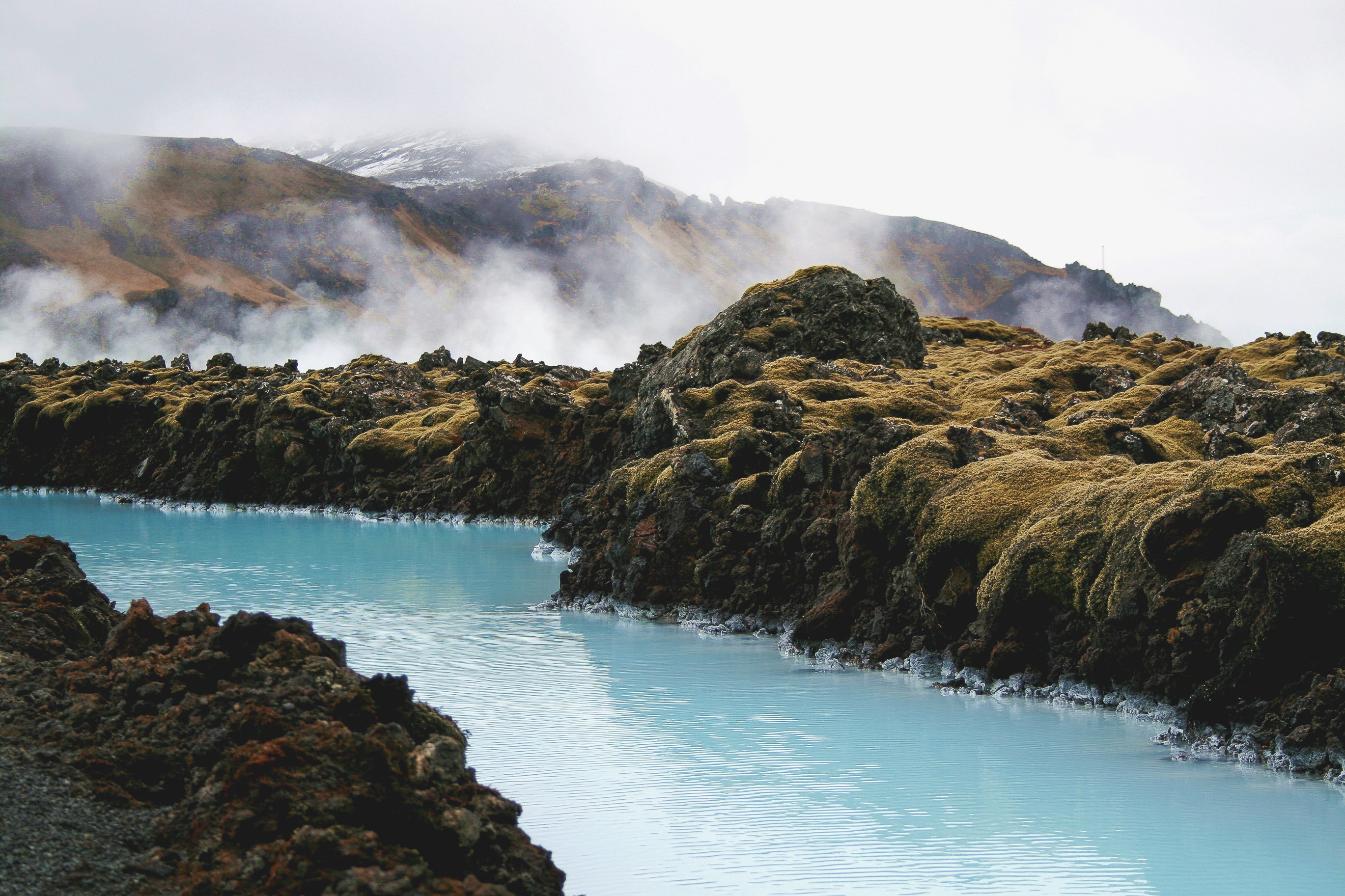 Blue Lagoon with Mossy Rocks and Misty Mountains in Iceland HD Wallpaper