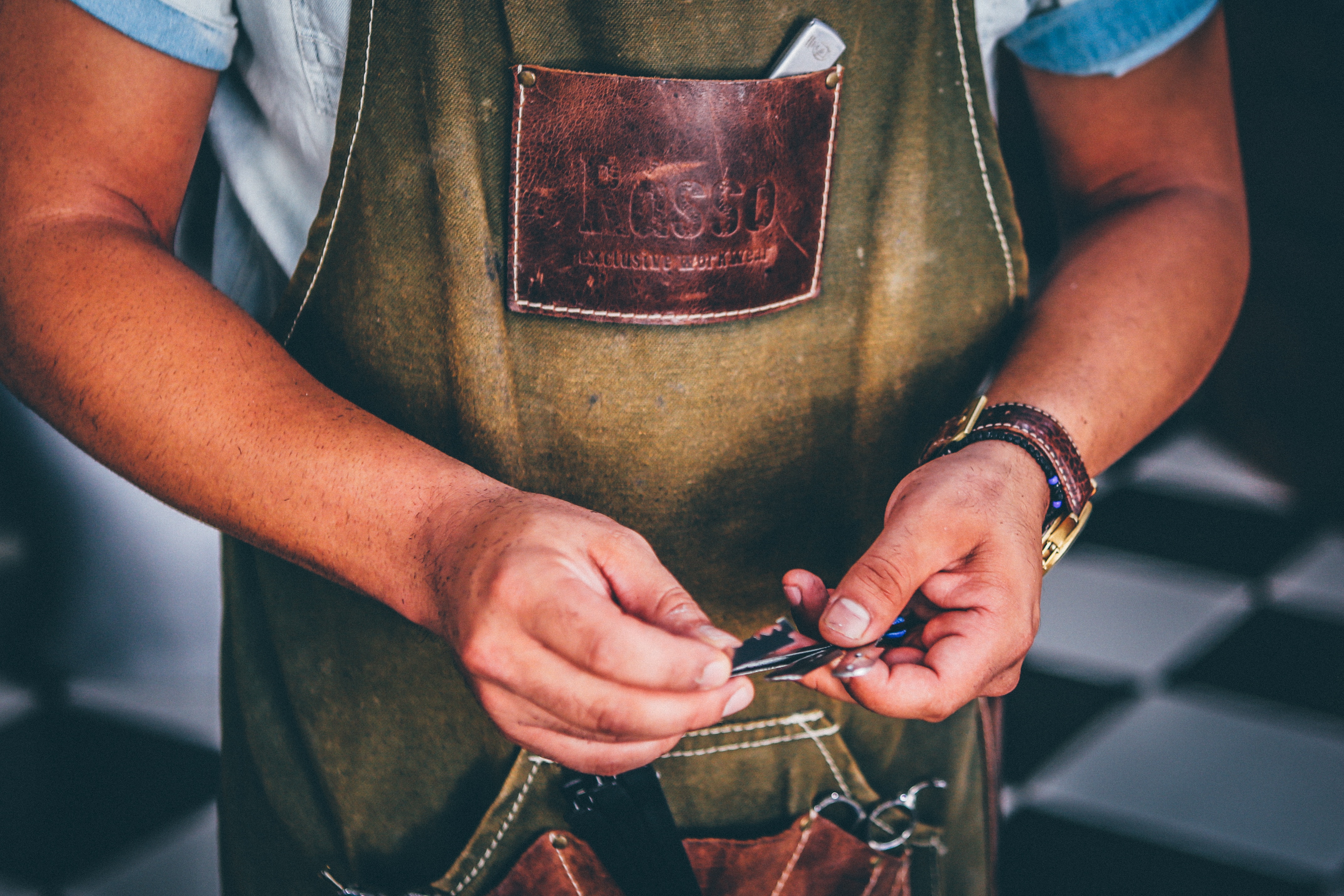 Barber with Kasso apron holding blades HD Wallpaper