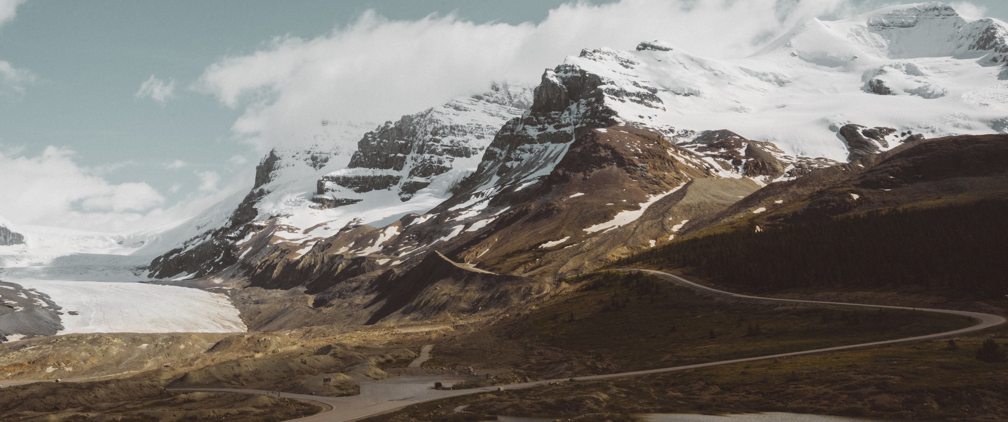 Snowy mountains and a winding road HD Wallpaper