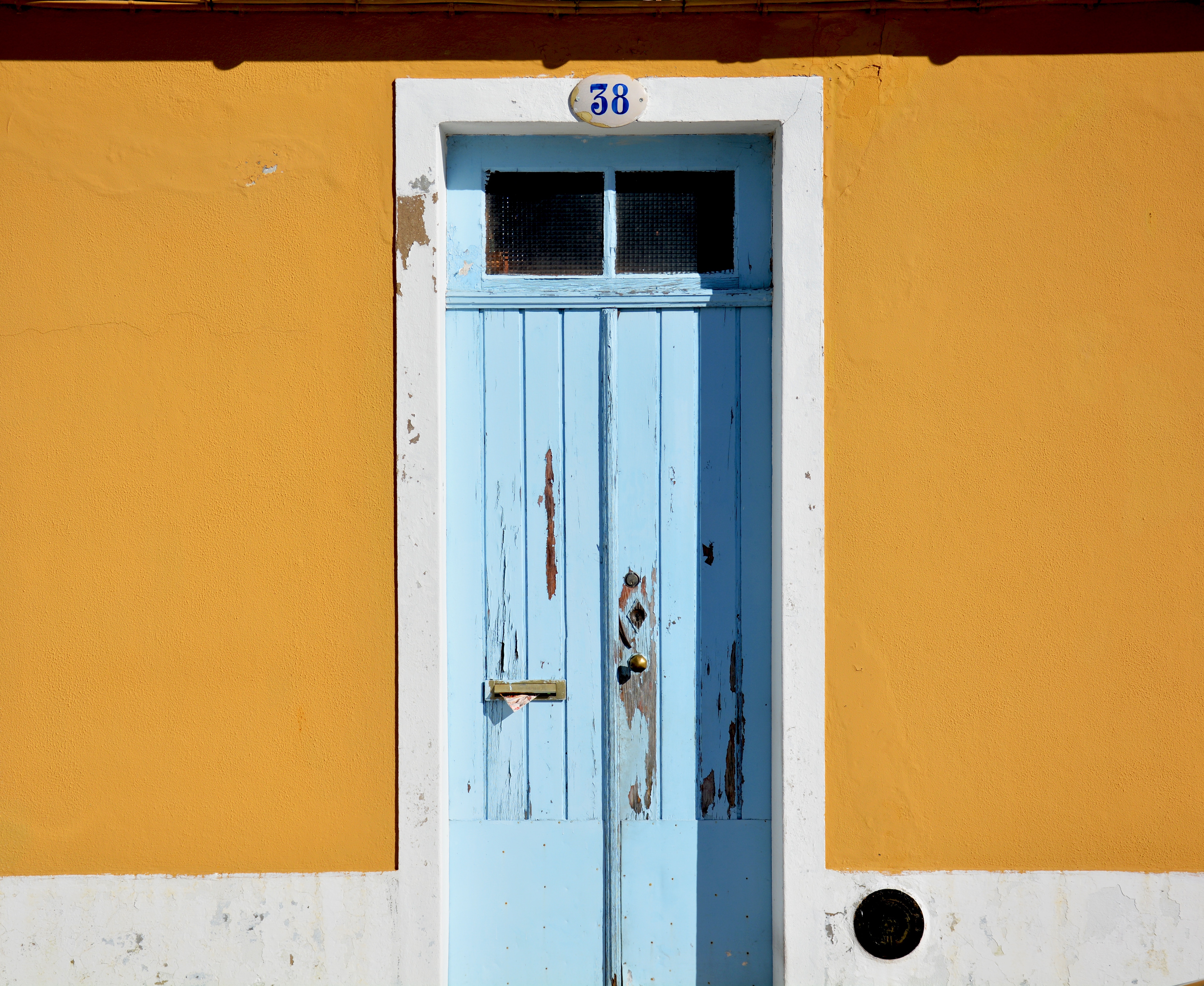 Weathered blue door with number 38 on orange wall HD Wallpaper