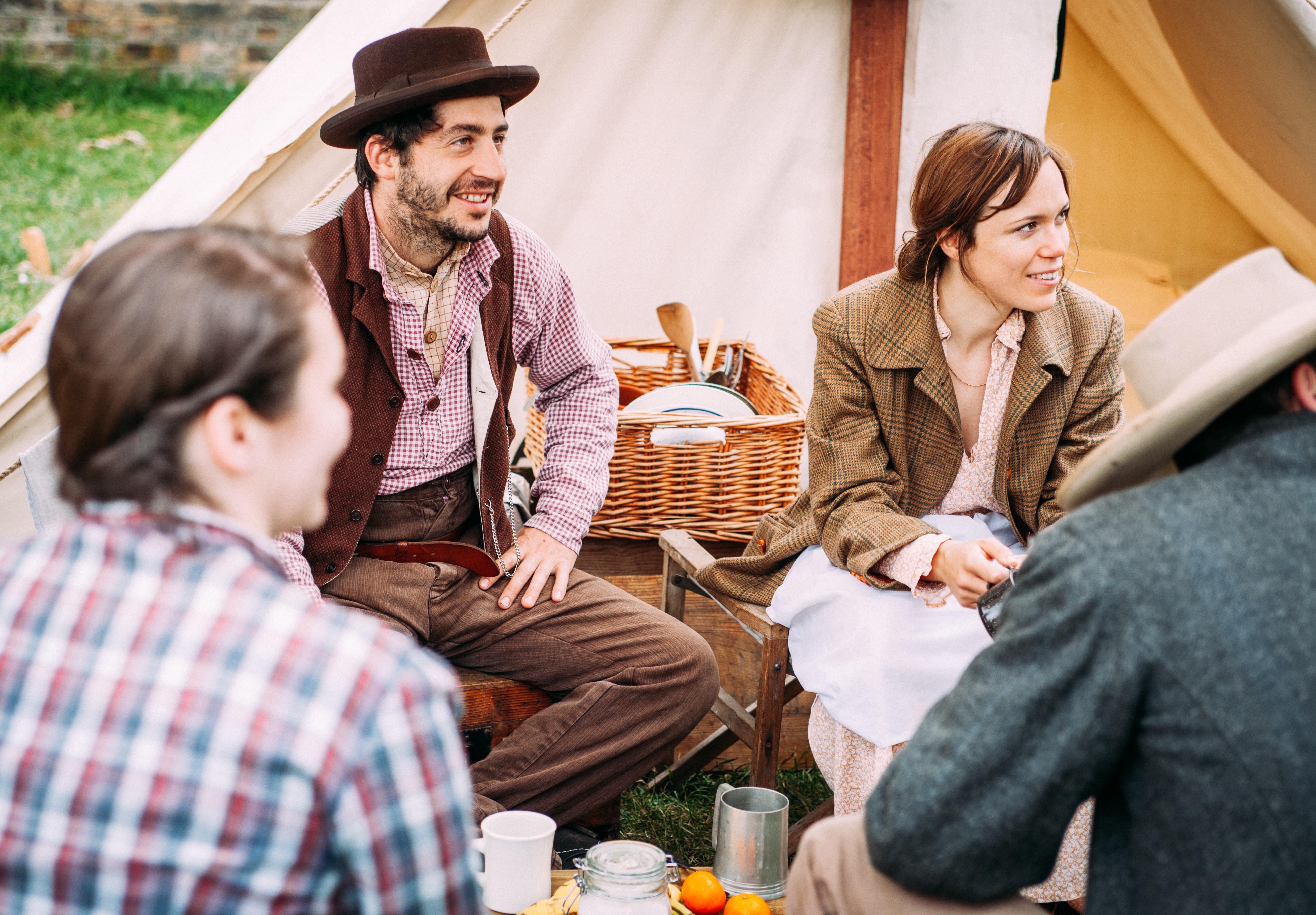 People in historical costumes gathered at a campsite HD Wallpaper
