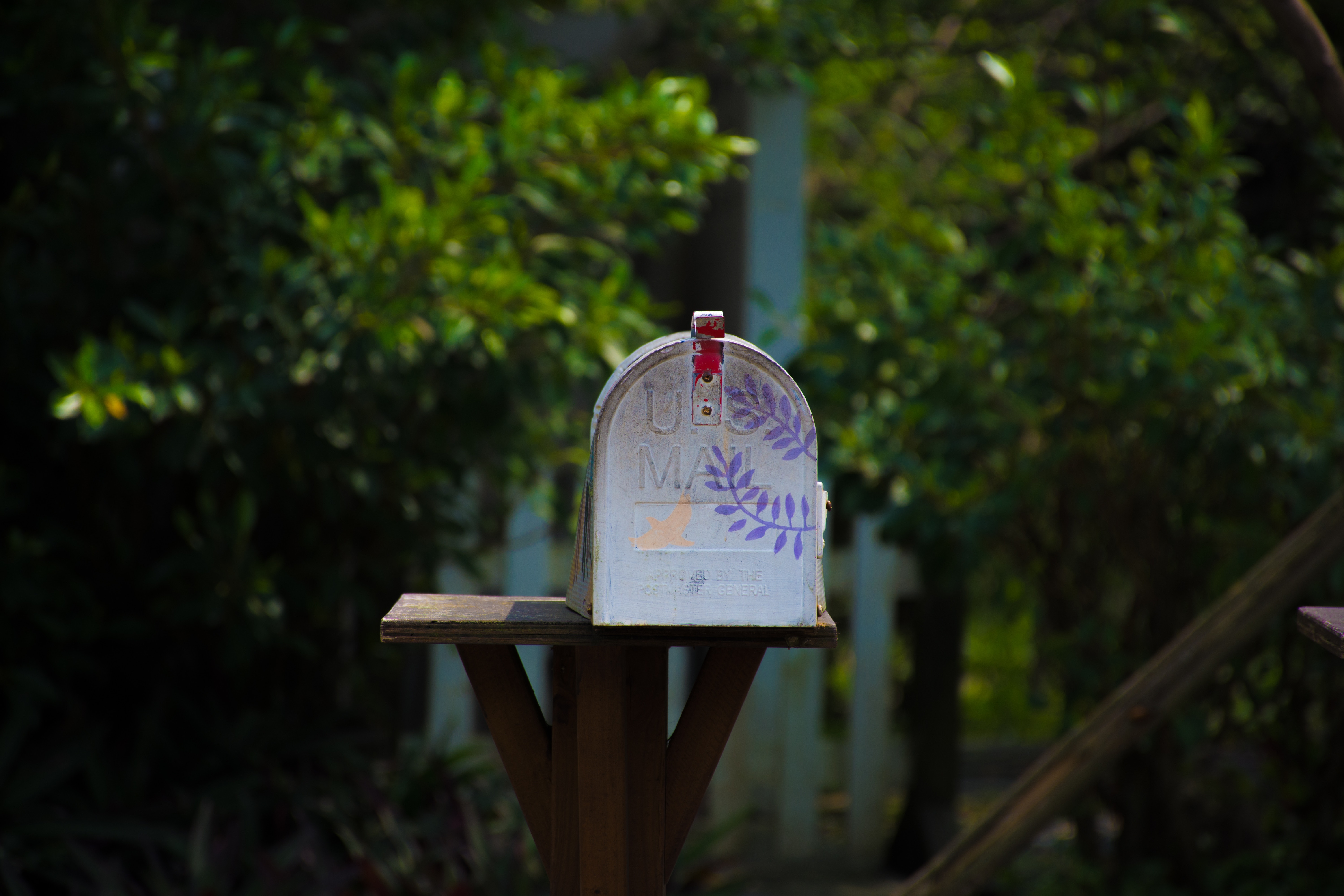 White mailbox with purple leaf stencil in a garden HD Wallpaper