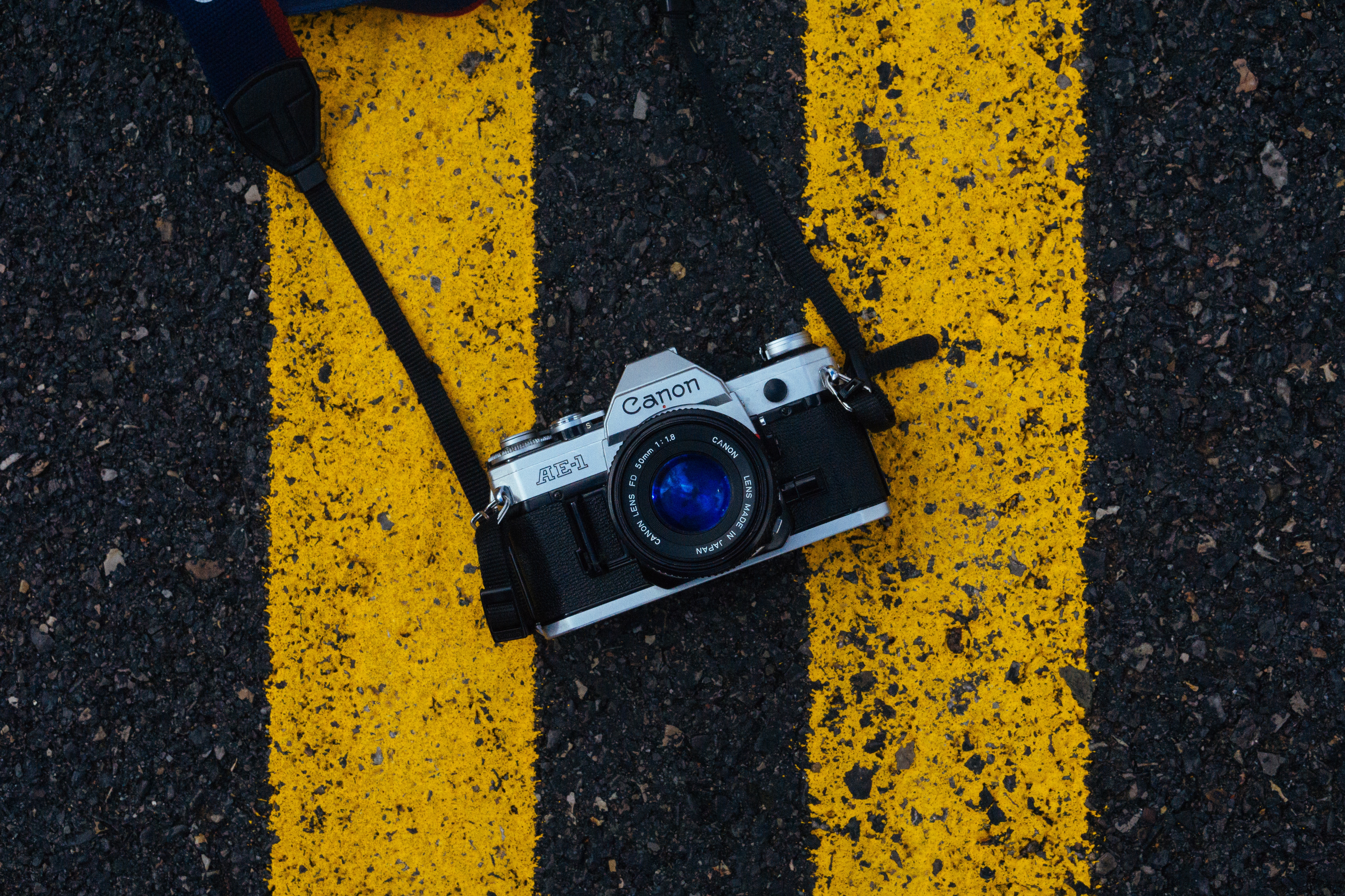 Canon AE-1 camera on yellow and black lines HD Wallpaper