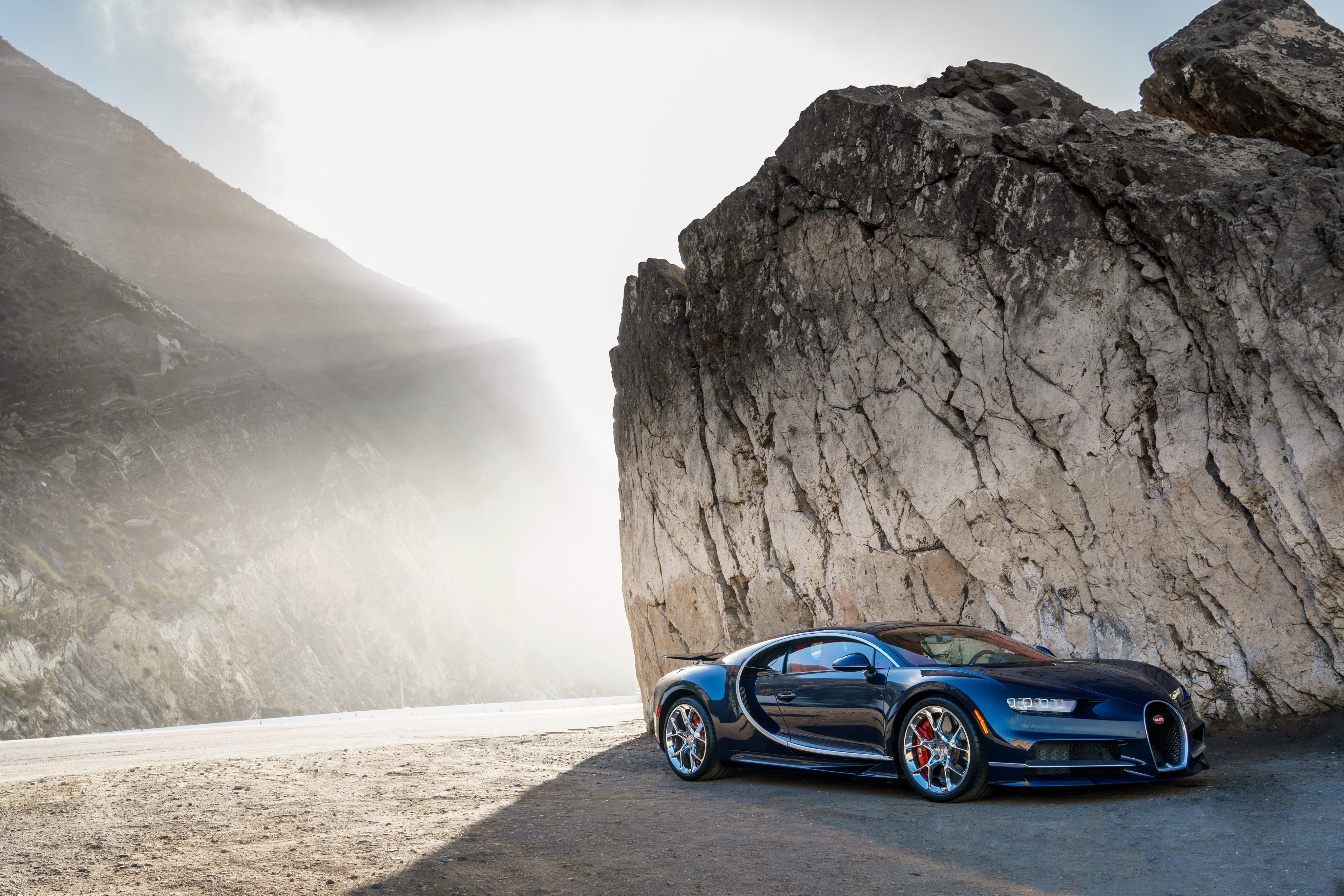 Bugatti Chiron parked by a large rock formation HD Wallpaper