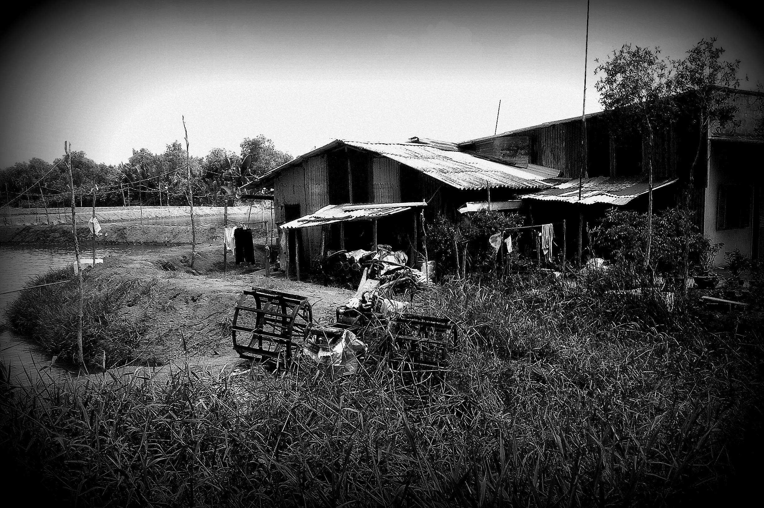Rural Vietnamese farm buildings by a river HD Wallpaper