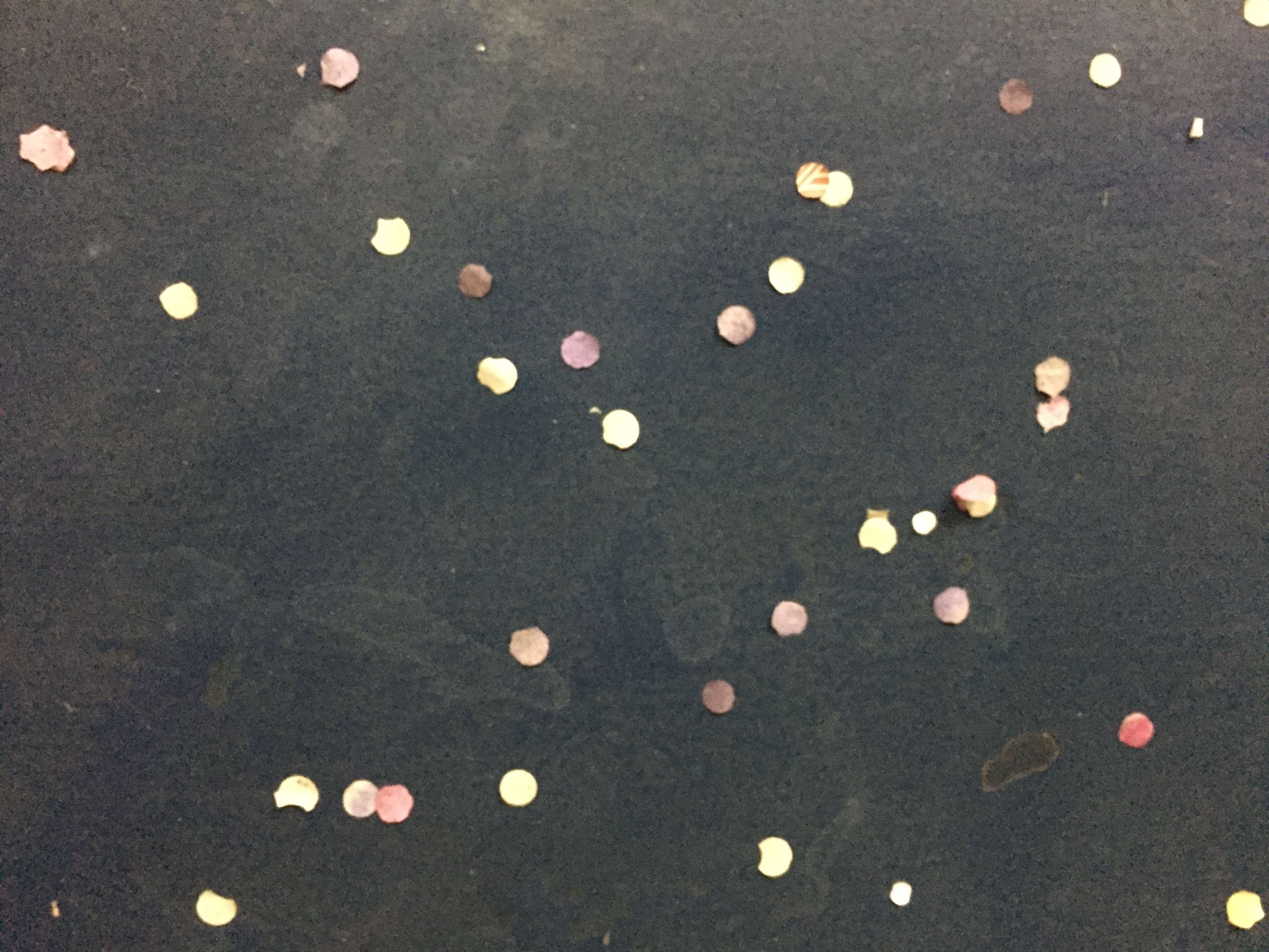 Confetti scattered on a dark surface HD Wallpaper